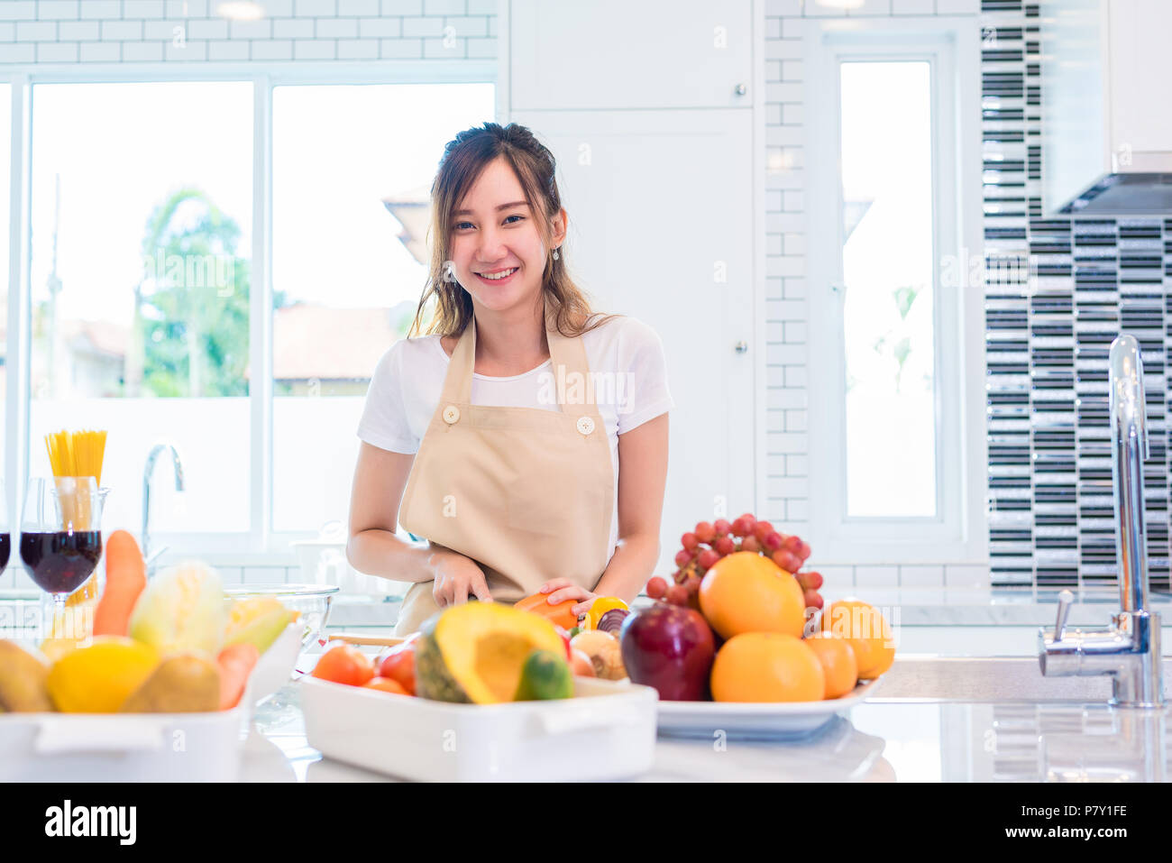 Asiatische junge Frau zum Abendessen kochen in der Küche zubereiten. Essen und Getränke Konzept. Schönheit und einzelne Mamma Konzept. Glückliches Leben und Lifestyle Thema. Interi Stockfoto