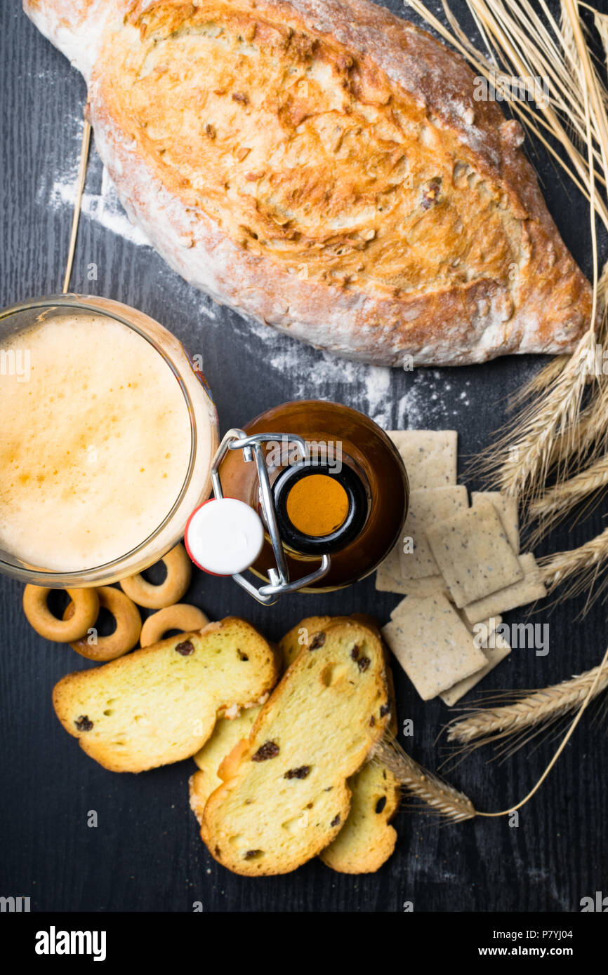 Vollkornbrot aus Weizen-, Roggen- und Leinsamen, Weizen und Vollkornbrot Gebäck mit Rosinen und Kurkuma, Oliven, Bagels mit Ale Bier Stockfoto
