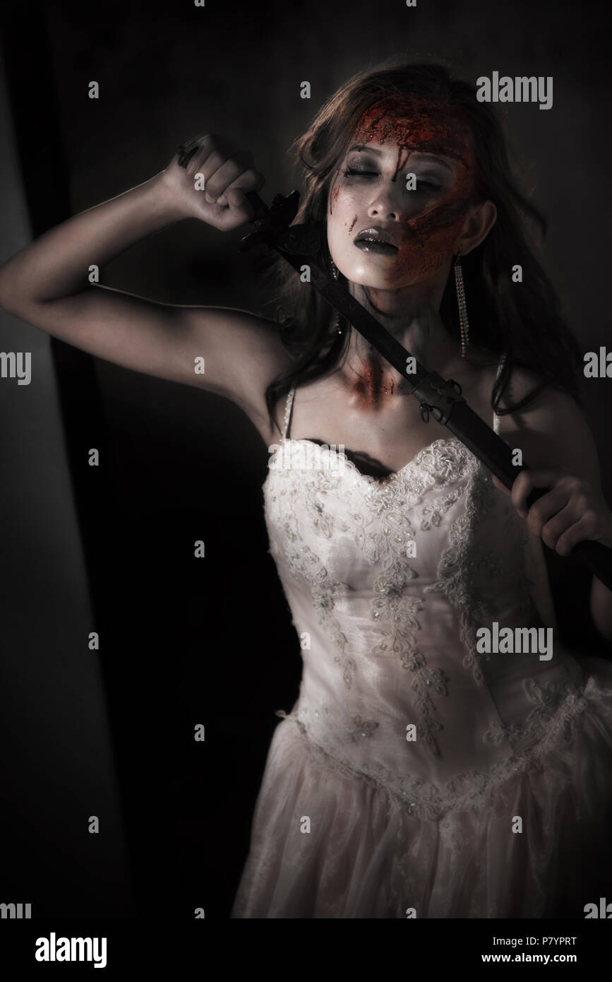Zombie lady Leiche holding Schwert, sich selbst zu töten, während Hochzeit. Horror und Ghost Konzept für Tag theme Event's Halloween. Dunkel und grunge Ton film Stockfoto