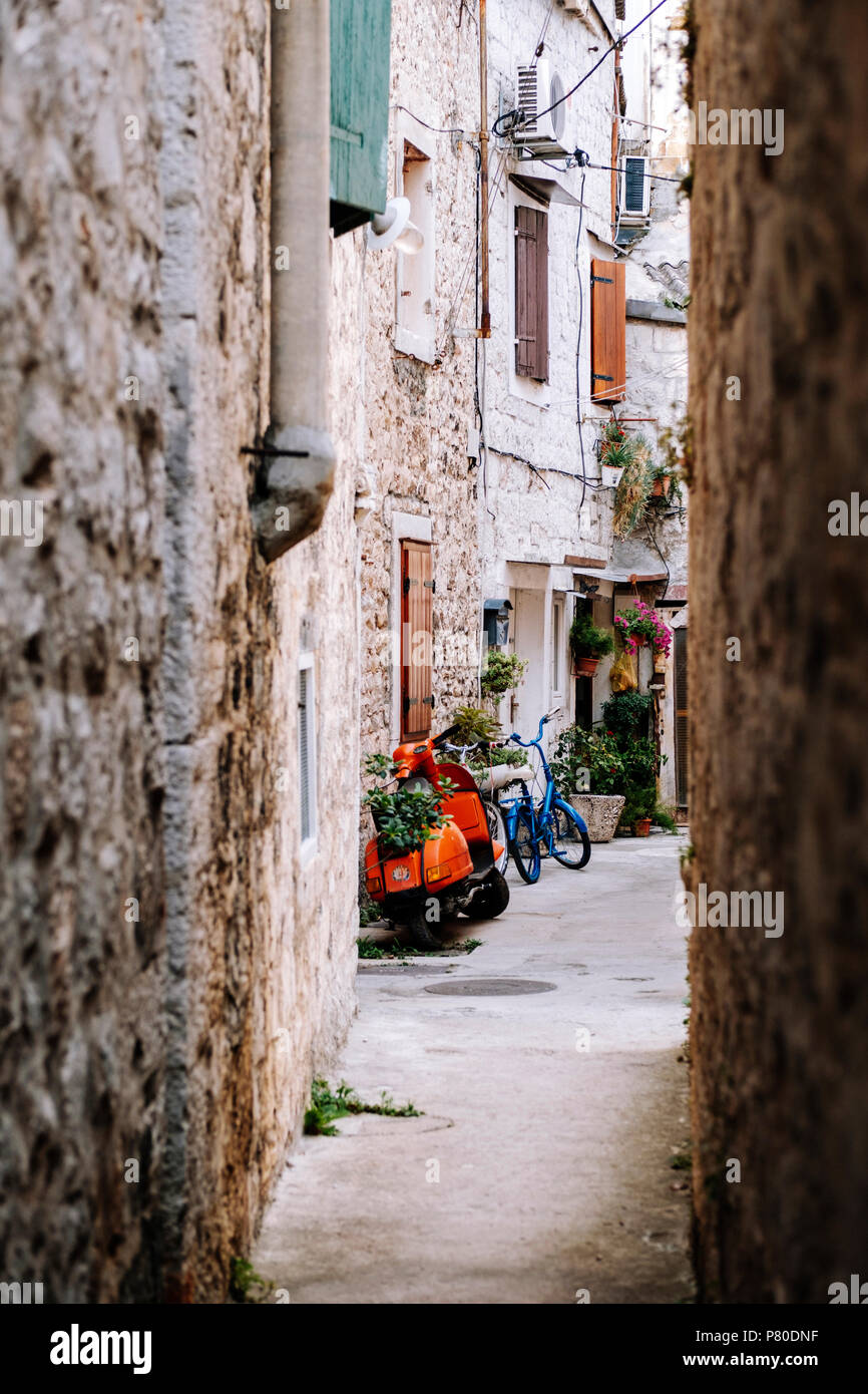 Roller und Fahrrad in einer idyllischen mediterranen Backstreet Stockfoto