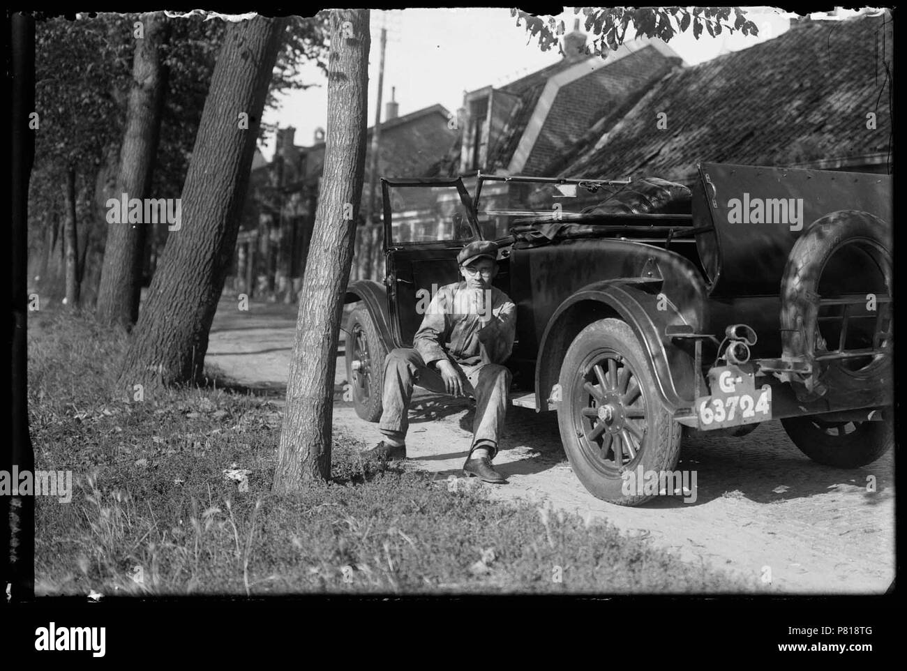1932. Chauffeur op geparkeerde treeplank van personenauto aan de Keizersgracht in Den Helder. Catalogusnummer: RAA 003012638 Collectie Regionaal Archief Alkmaar. 1 Januar 1932, 00:00 29 Auto in Den Helder (27333198272) Stockfoto