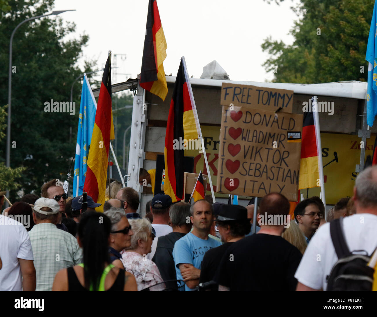 Kandel, Deutschland. 07 Juli, 2018. Rechtsextreme Demonstranten hören Sie eine Rede auf der Kundgebung, halten deutsche Fahnen und ein Zeichen dafür, dass Anrufe für eine Freilassung der britischen rechtsextremen Aktivisten Tommy Robinson und zeigt ihre Unterstützung für Donald Trump, Wladimir Putin, Viktor Orban, Sebastian Kurz (österreichischer Bundeskanzler) und Italien. Rund 200 Menschen von Rechten Organisationen protestierten für das 10. mal in der Stadt Kandel in der Pfalz gegen Flüchtlinge, Ausländer und der deutschen Regierung. Sie forderten mehr Sicherheit von Deutschen und Frauen aus der angeblichen Zunahme der Gewalt durch Flüchtlinge. An die Stelle der Protein Stockfoto