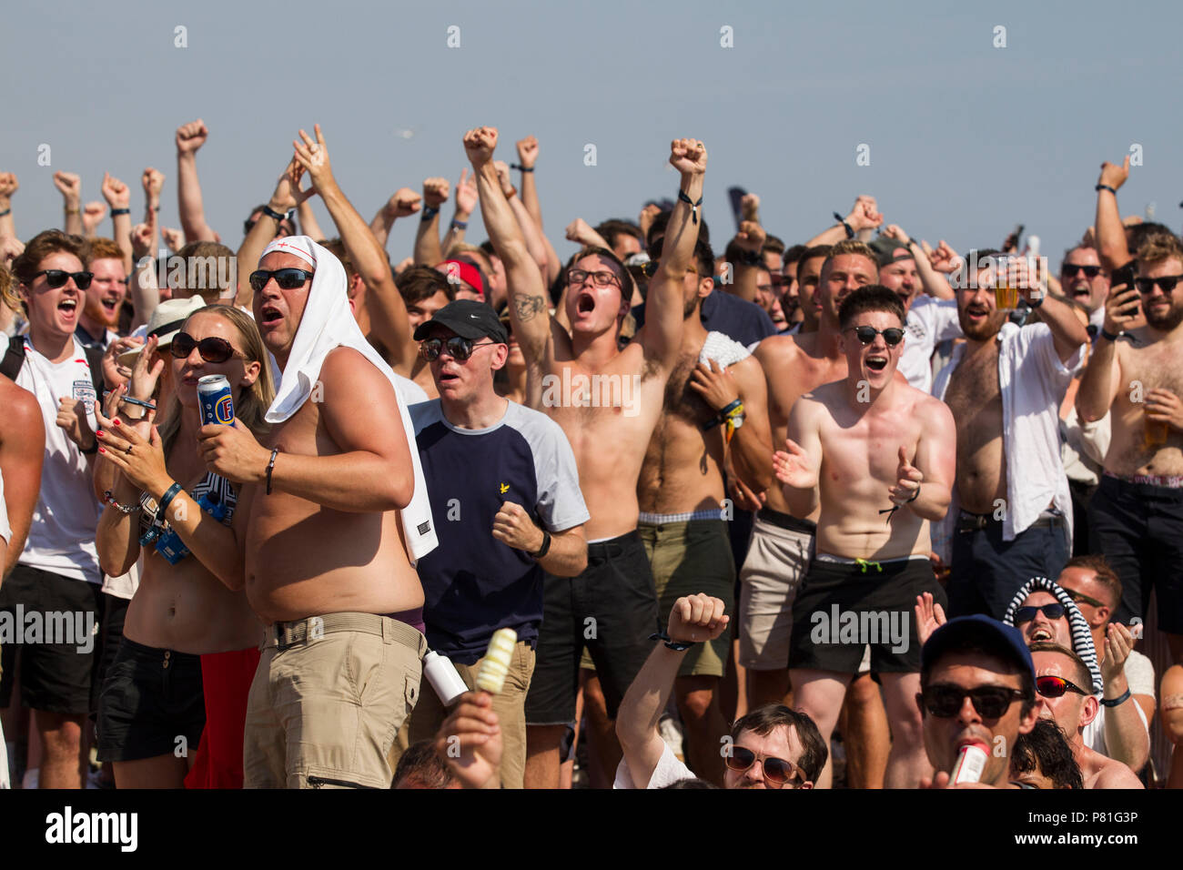 England Fußball-Fans der WM-Viertelfinale England v Schweden auf einem riesigen TV-Bildschirm am Strand von Brighton in England das Halbfinale erreichen. Großbritannien Stockfoto