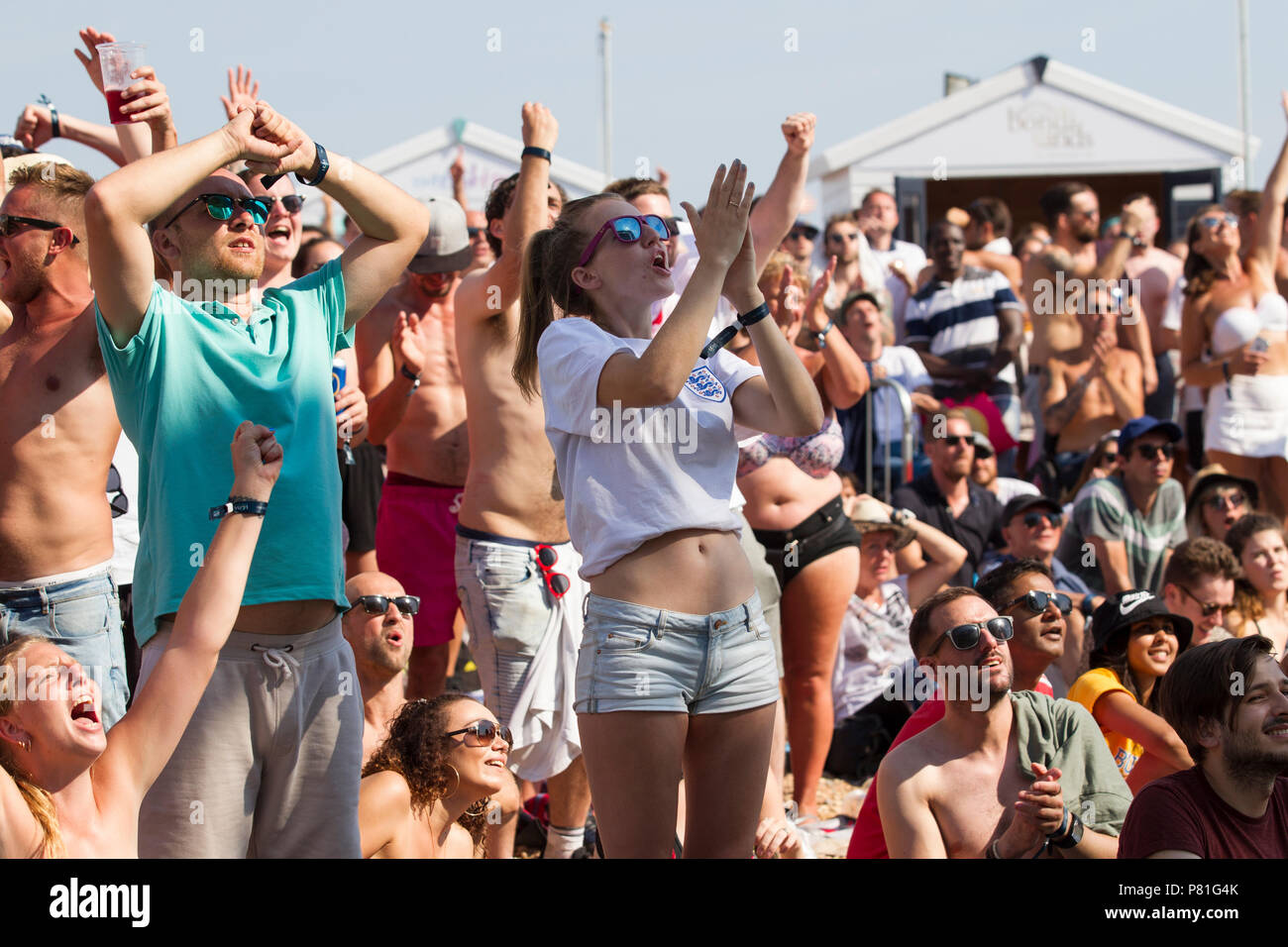 England Fußball-Fans der WM-Viertelfinale England v Schweden auf einem riesigen TV-Bildschirm am Strand von Brighton in England das Halbfinale erreichen. Großbritannien Stockfoto