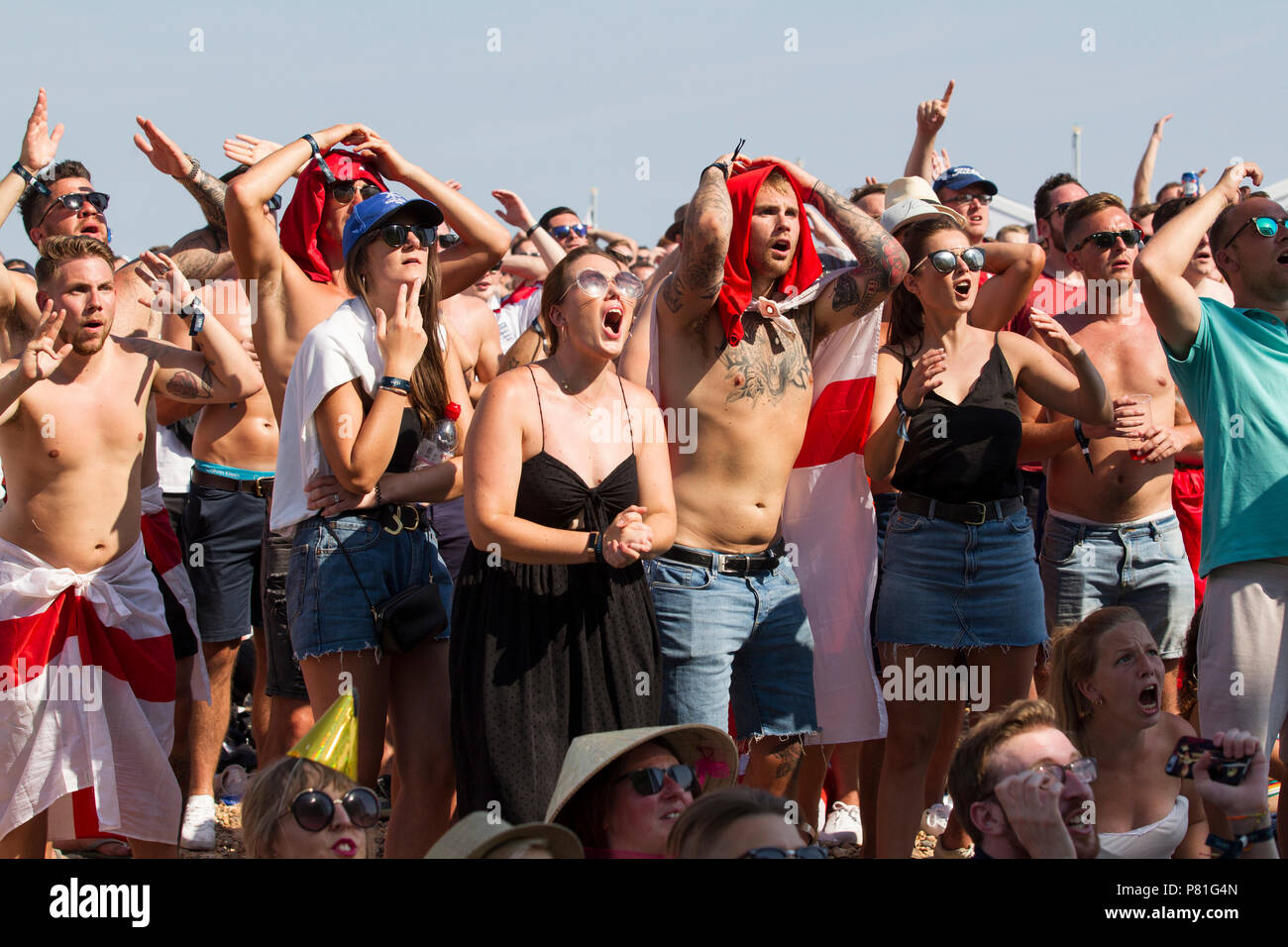 England Fußball-Fans der WM-Viertelfinale England v Schweden auf einem riesigen TV-Bildschirm am Strand von Brighton in England das Halbfinale erreichen. Großbritannien Stockfoto