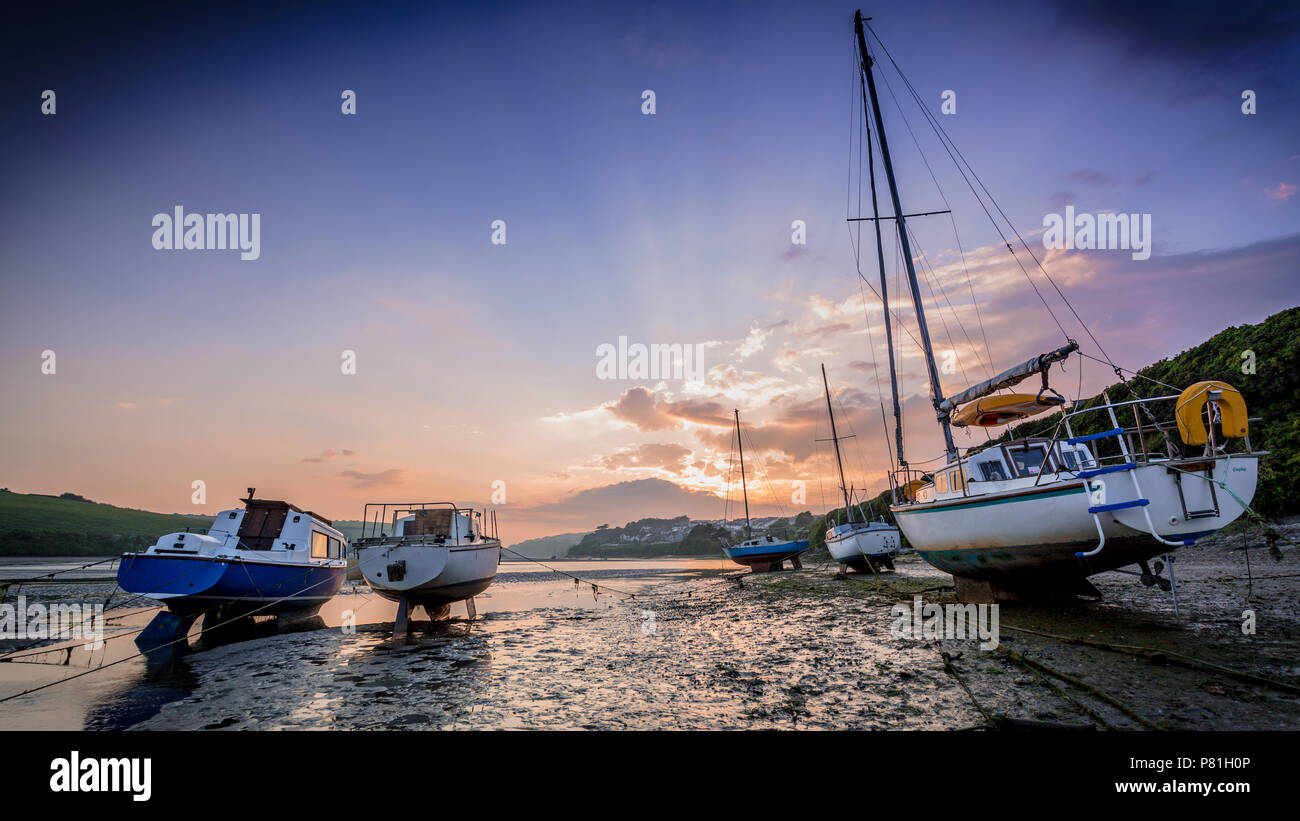 Die untergehende Sonne wirft Sie atemberaubende Farben über Landschaft und Boote der Fluss Gannel, Newquay Stockfoto