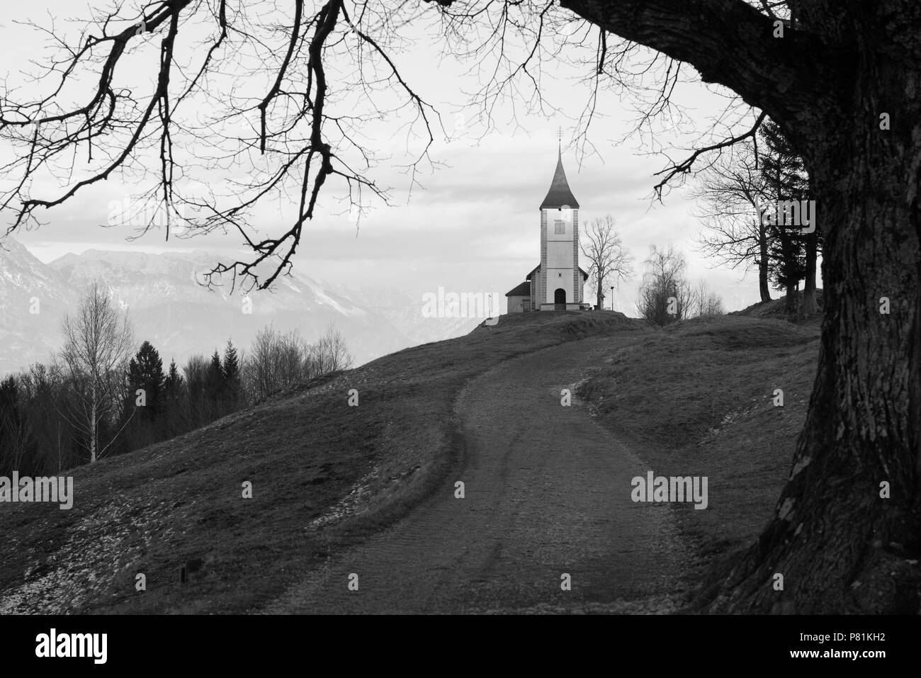 Kirche St. Primoz in der Dämmerung in der Nähe von Jamnik, vor der dramatischen Kulisse des Mount Storzic, Gorenjska, Slowenien, Europa Stockfoto