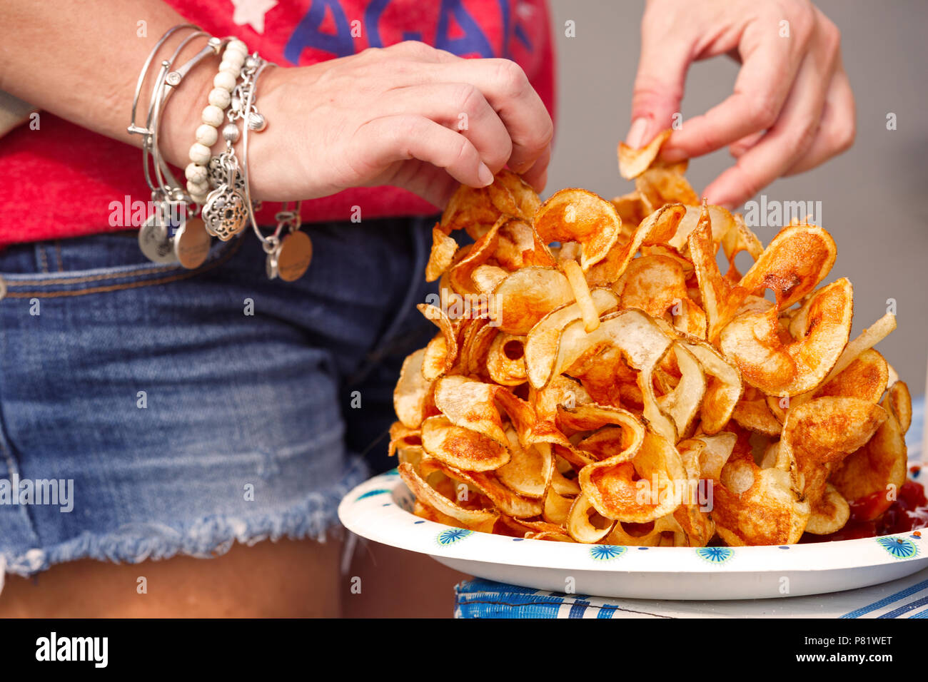 Frau mit Spirale - geschnittenen Chips auf einem US-Unabhängigkeitstag Feier der Gemeinschaft Stockfoto