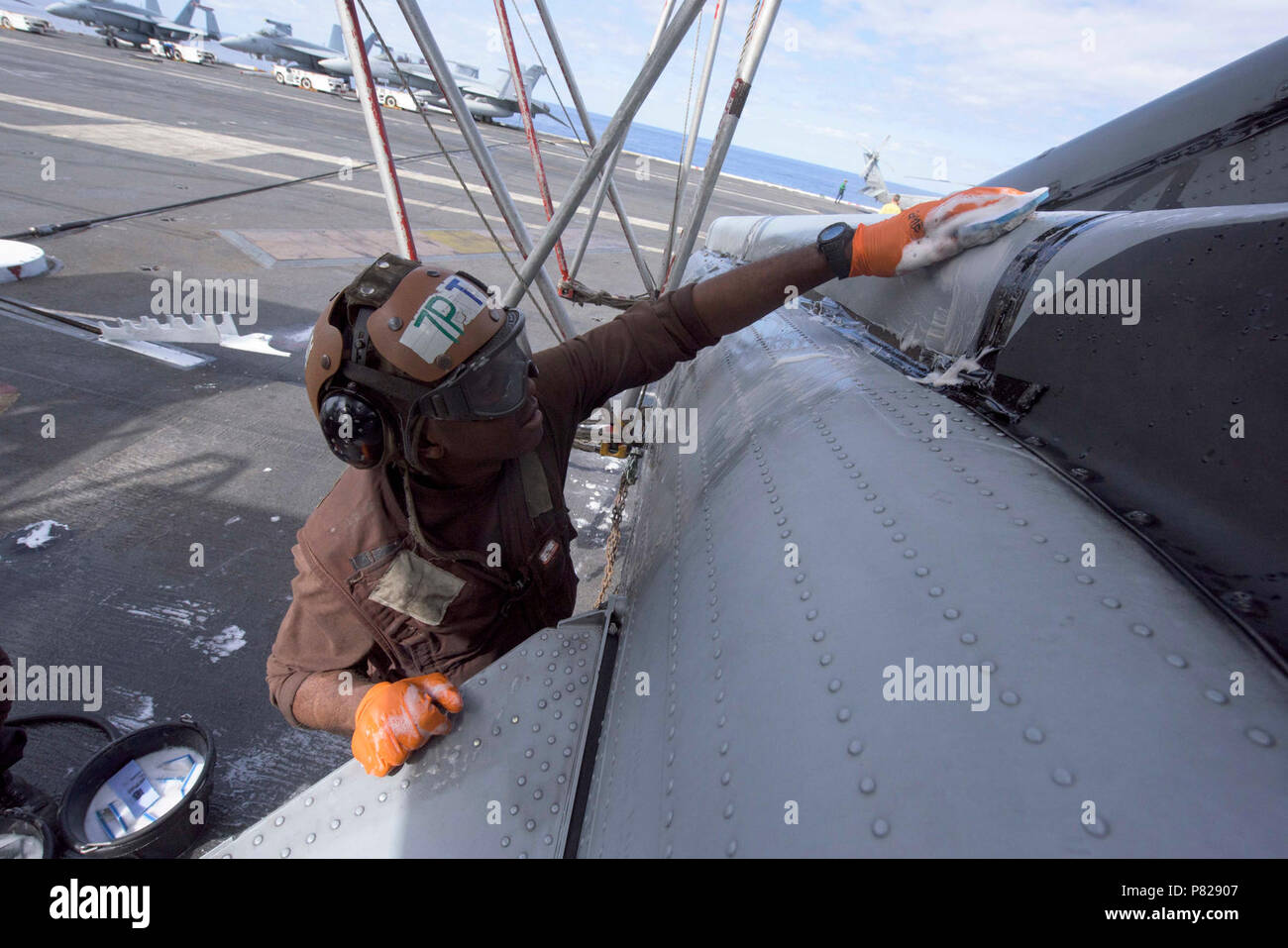 Ozean (April 4, 2016) - Flieger Lambert Gayle wäscht einem MH-60S Sea Hawk Hubschrauber zu den staubigen Hunde der Hubschrauber Meer Combat Squadron (HSC) 7 zugeordnet auf dem Flugdeck der Flugzeugträger USS Dwight D. Eisenhower (CVN 69), das Flaggschiff der Eisenhower Carrier Strike Group. Ike ist unterwegs die Durchführung einer Composite Trainingsgerät Übung (COMPTUEX) mit der Eisenhower Carrier Strike Group in der Vorbereitung für einen zukünftigen Einsatz. Stockfoto