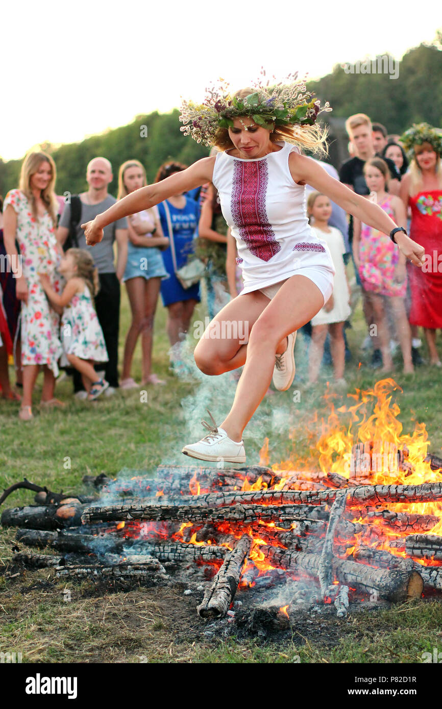 Kiew, Ukraine - Juli 6, 2018: Junge Frau springt über die Flammen der Lagerfeuer während des traditionellen slawischen Feier von Ivana Kupala Holiday in Pirogo Stockfoto