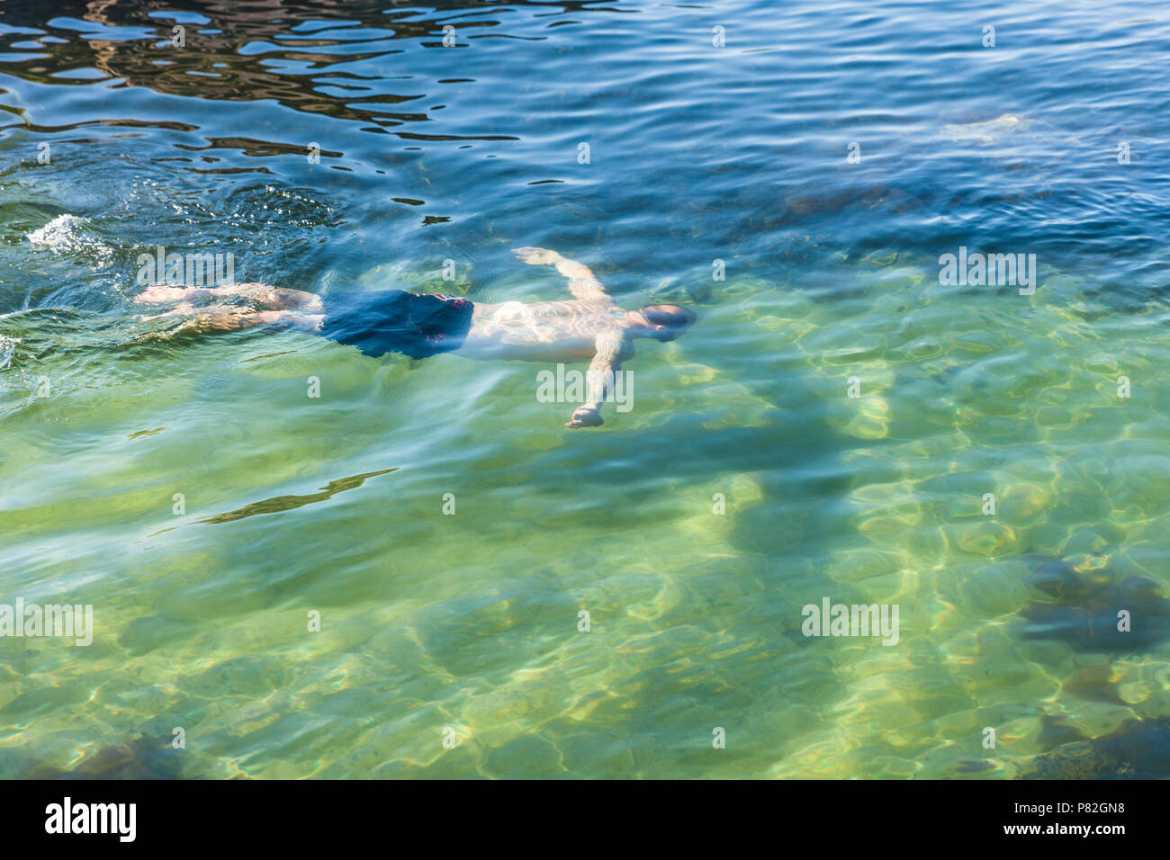 Ein Mann Tauchen und Schwimmen unter Wasser über einen schönen Sand unten. Stockfoto