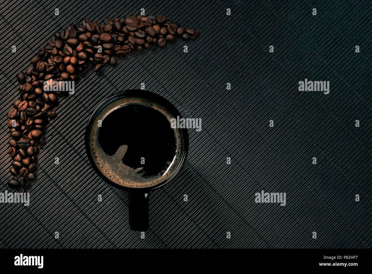 Schwarzer Kaffeebecher in der Nähe von Kaffeebohnen auf Moody Hintergrund Stockfoto