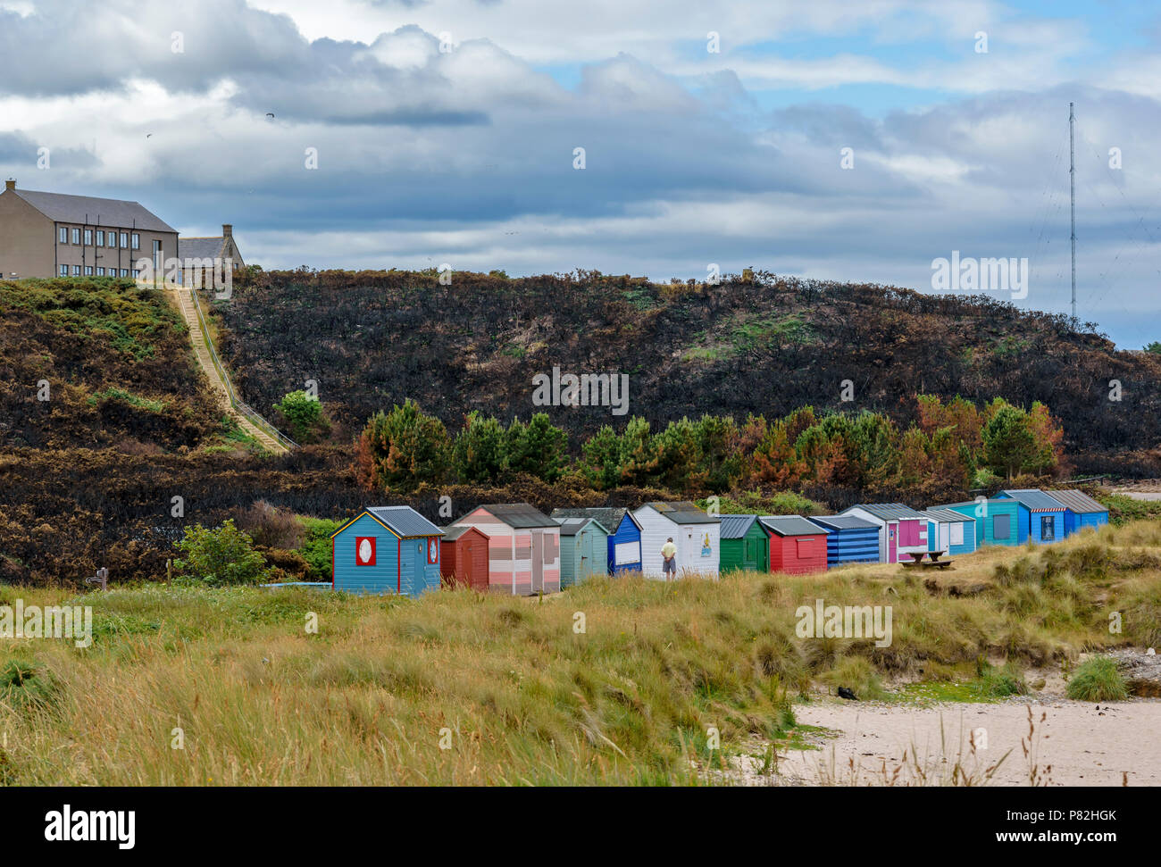 HOPEMAN Moray in Schottland Strand Hütten oder CHALETS ÜBERSEHEN DURCH BEREICH DES VERBRANNTEN GINSTER UND VEGETATION WEGEN WILDFIRE Stockfoto