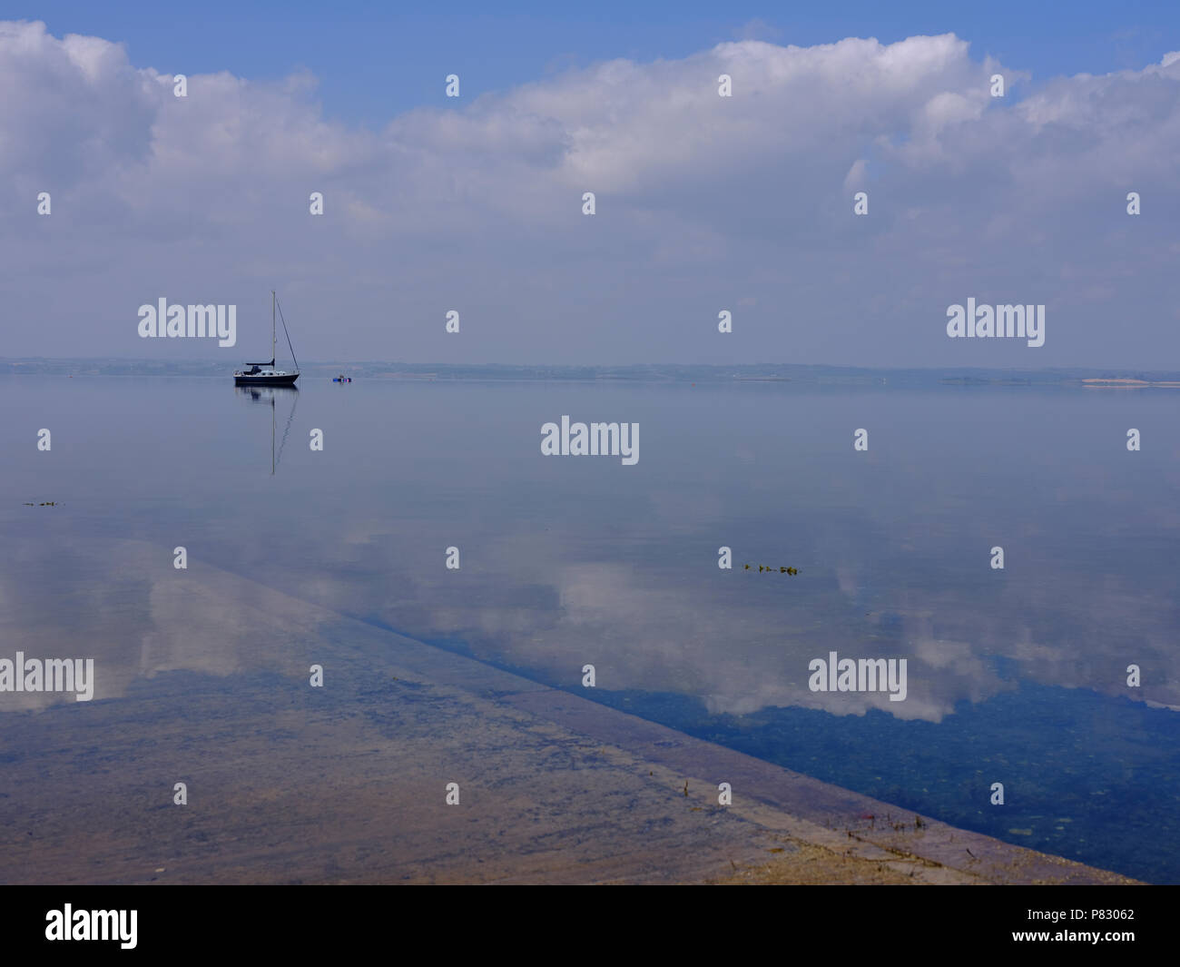 Landschaft Blick über Strangford Lough im Sommer Nebel und klare Reflexionen von Wolken und Boote am Horizont. Stockfoto