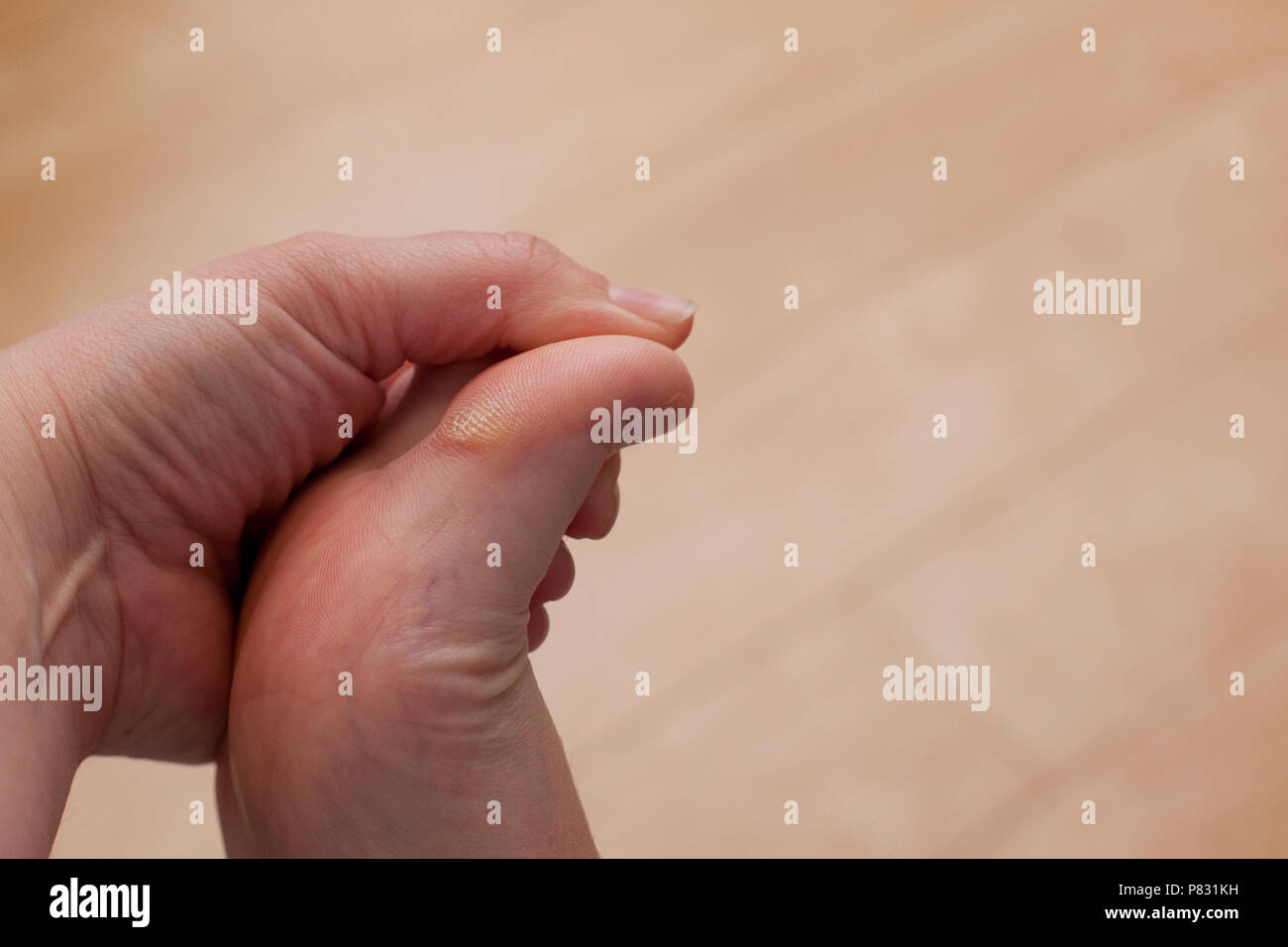 Eine Hand hält auf ihren Fuß, berührend und an eine verhärtete und trockenen rauhen Big Toe suchen Stockfoto