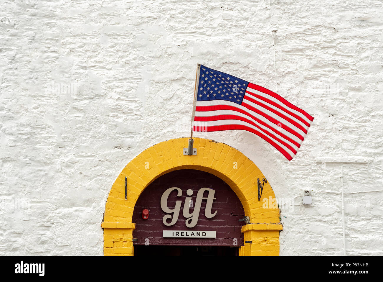 Im irischen Souvenirladen in Kinsale, County Cork, Irland, winkt die amerikanische Flagge gegen die weiße Wand Stockfoto