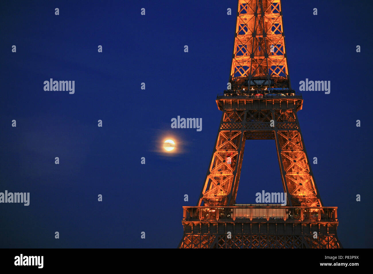 Eiffelturm bei Nacht beleuchtet mit Vollmond im Hintergrund, Paris, Frankreich, Europa Stockfoto