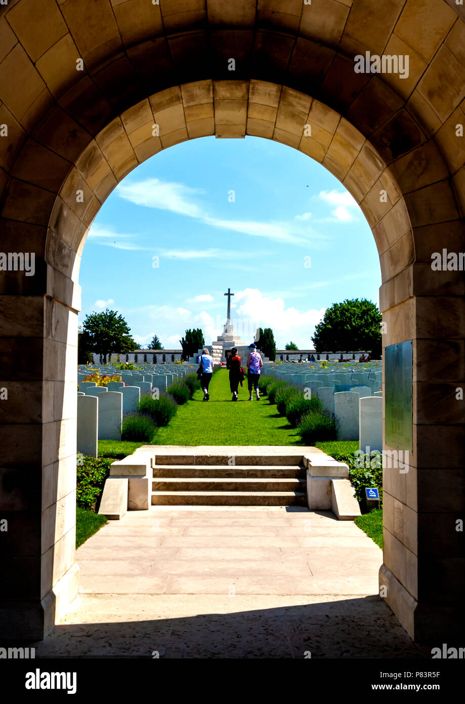 Die geschwungenen Bogen öffnet sich auf Grabsteinen und führt bis zum Kreuz des Opfers errichtet auf einem ehemaligen Deutschen Beton Bunker Stockfoto