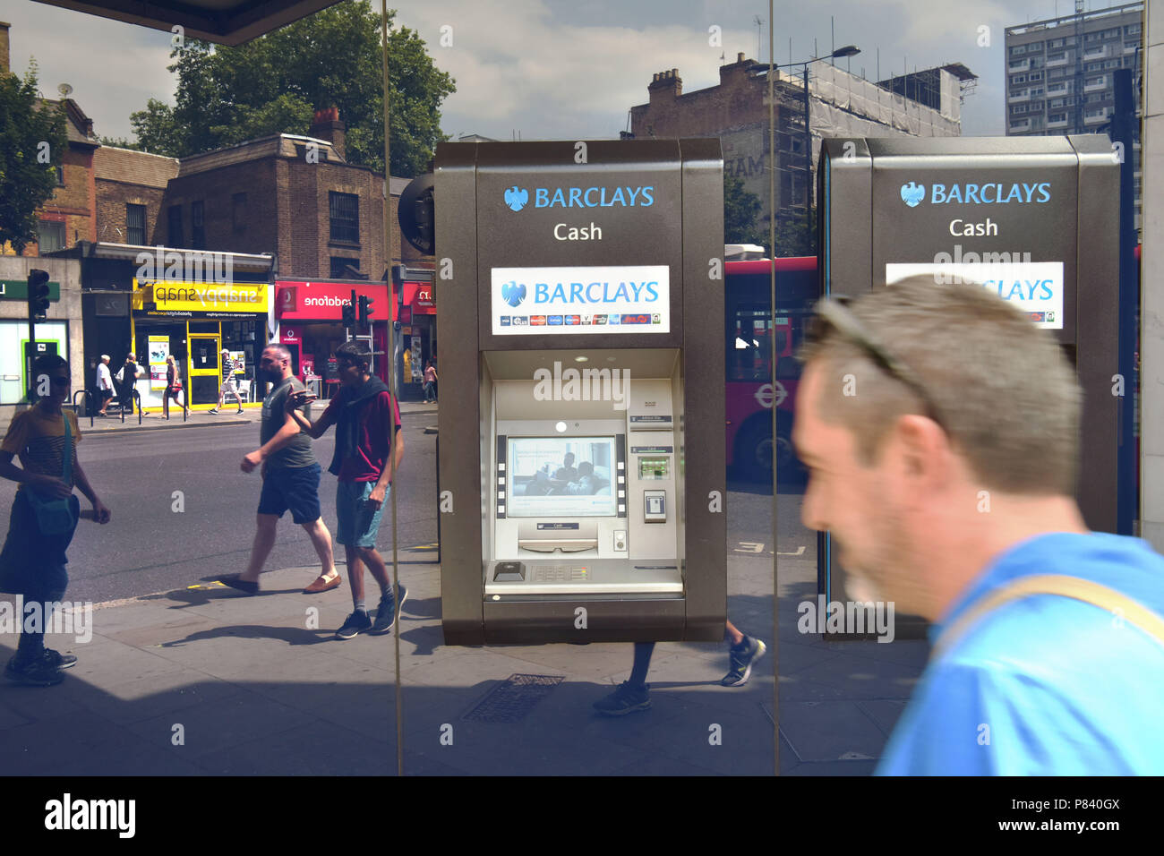 Menschen in das Fenster wider, Spaziergang, vorbei an die Bank Barclays ATM in Notting Hill, London. Stockfoto