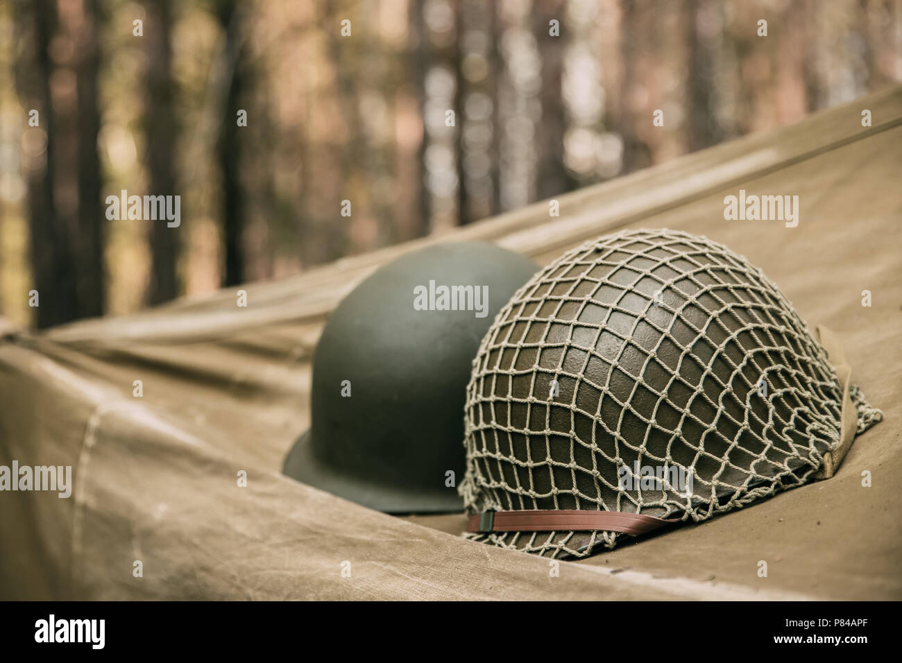 Metal Helm der United States Army Infantry Soldat im Zweiten Weltkrieg. Helm auf Camping Zelt in Forest Camp. Stockfoto