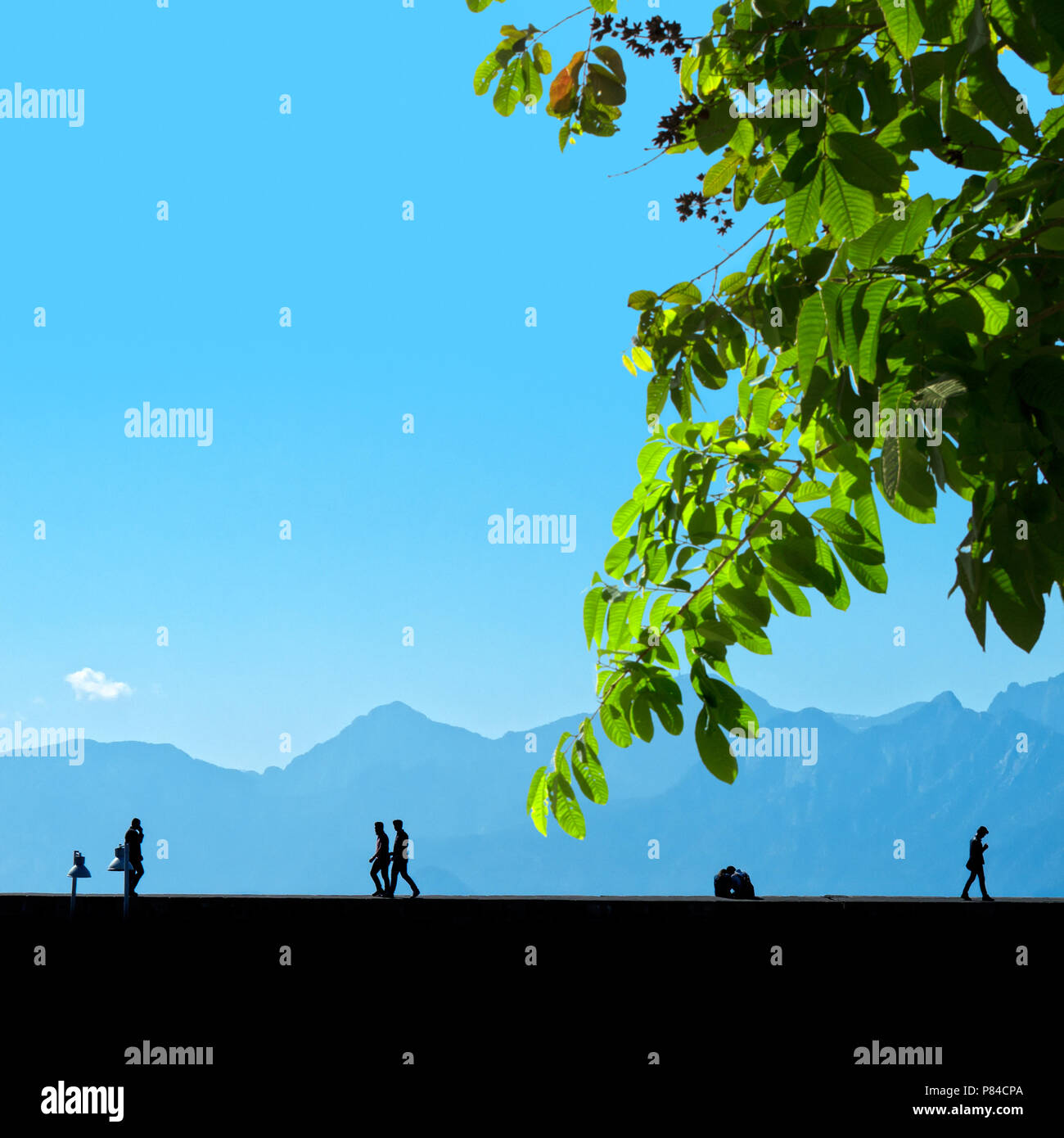 Silhouette Menschen entspannend auf der Straße über blauen Himmel und hohe Berge Stockfoto