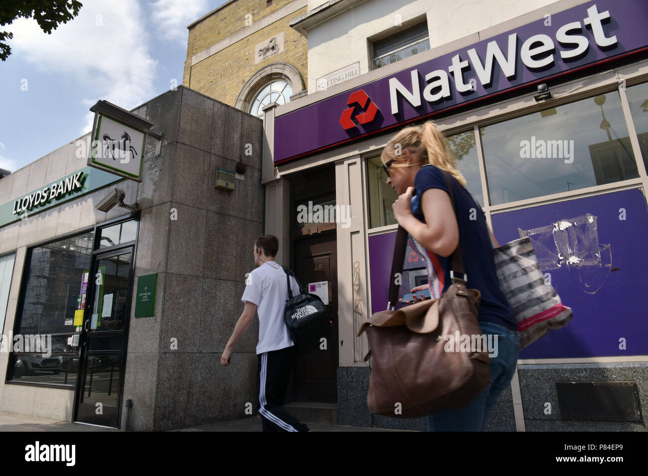 Menschen gehen vorbei an den Zweigen der NatWest und Lloyds Banken in Notting Hill London Stockfoto