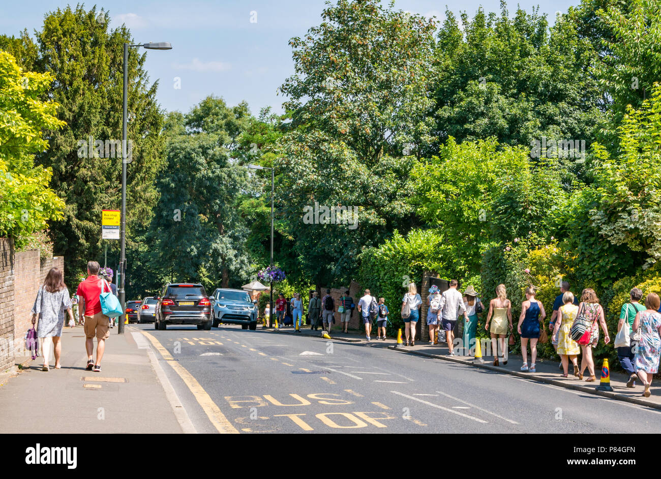 Lange Schlange von Menschen zu Fuß auf Bürgersteig zu All England Lawn Tennis Meisterschaft im Sommer, Wimbledon, London, England, Großbritannien Stockfoto