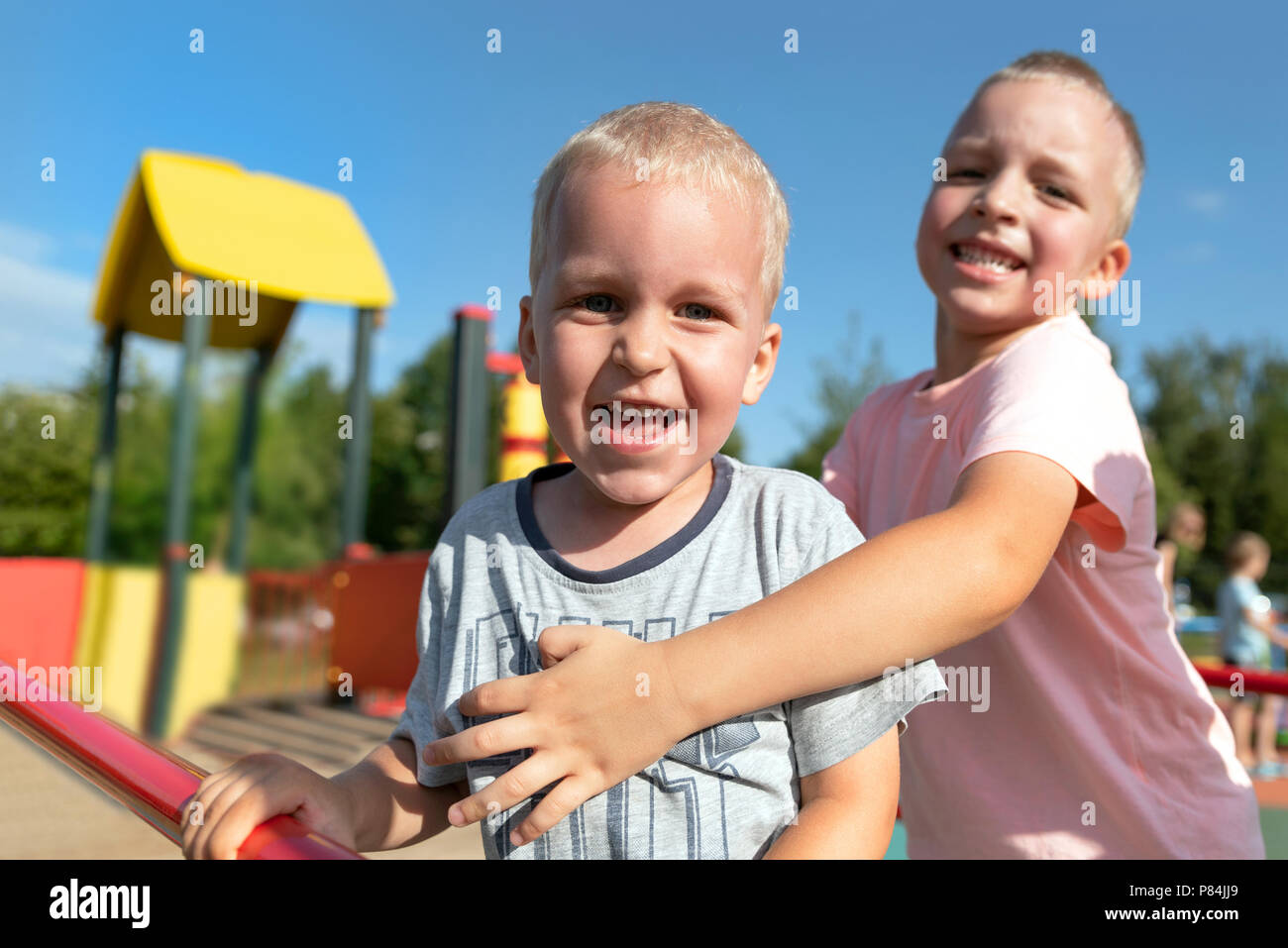 Zwei kleine Jungen, die zusammen spielen und Spaß haben. Lifestyle Familie Moment der Geschwister auf dem Spielplatz. Stockfoto