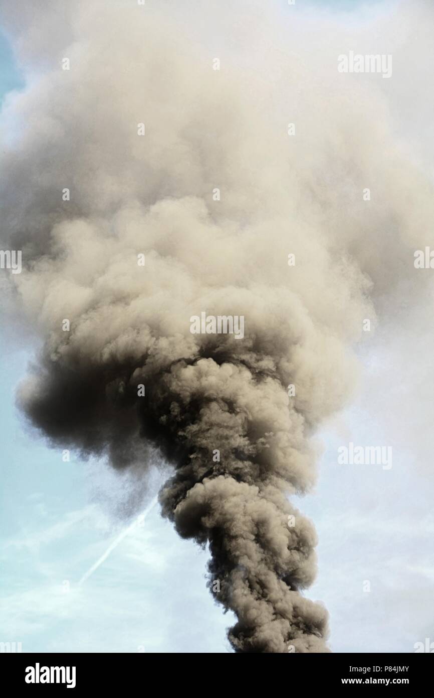 Verheerende Folgen für die Umwelt und die Verunreinigung der Luft durch große Rauchsäule aus dem Schornstein. Stockfoto