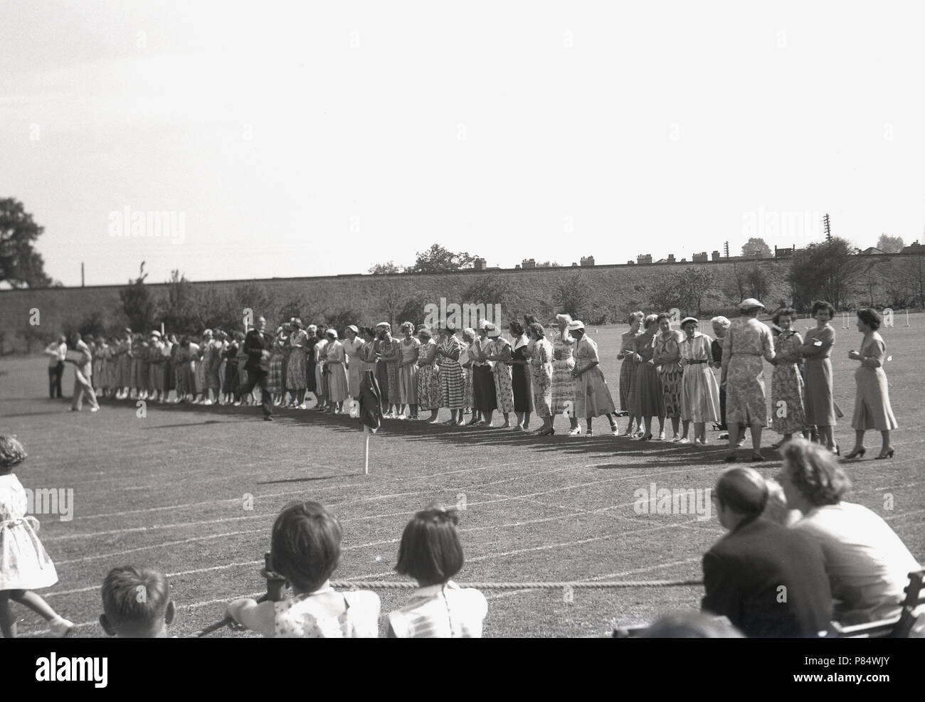 1950er Jahre, Historikall, an den Schulen Sporttag, alle Mütter, alle in Kleidern!, Line-up, um an einem Ei & Löffel Rennen teilnehmen, einer der traditionellen Wettbewerbe ihre Kinder an diesem Tag konkurrieren. Stockfoto