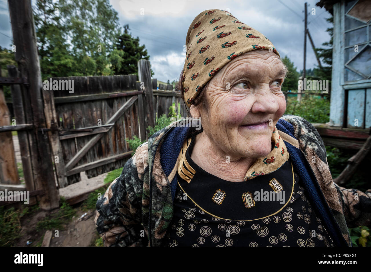 Eine alte lächelnde Frau, in Kazakistan, vor ihrem Haus. Stockfoto