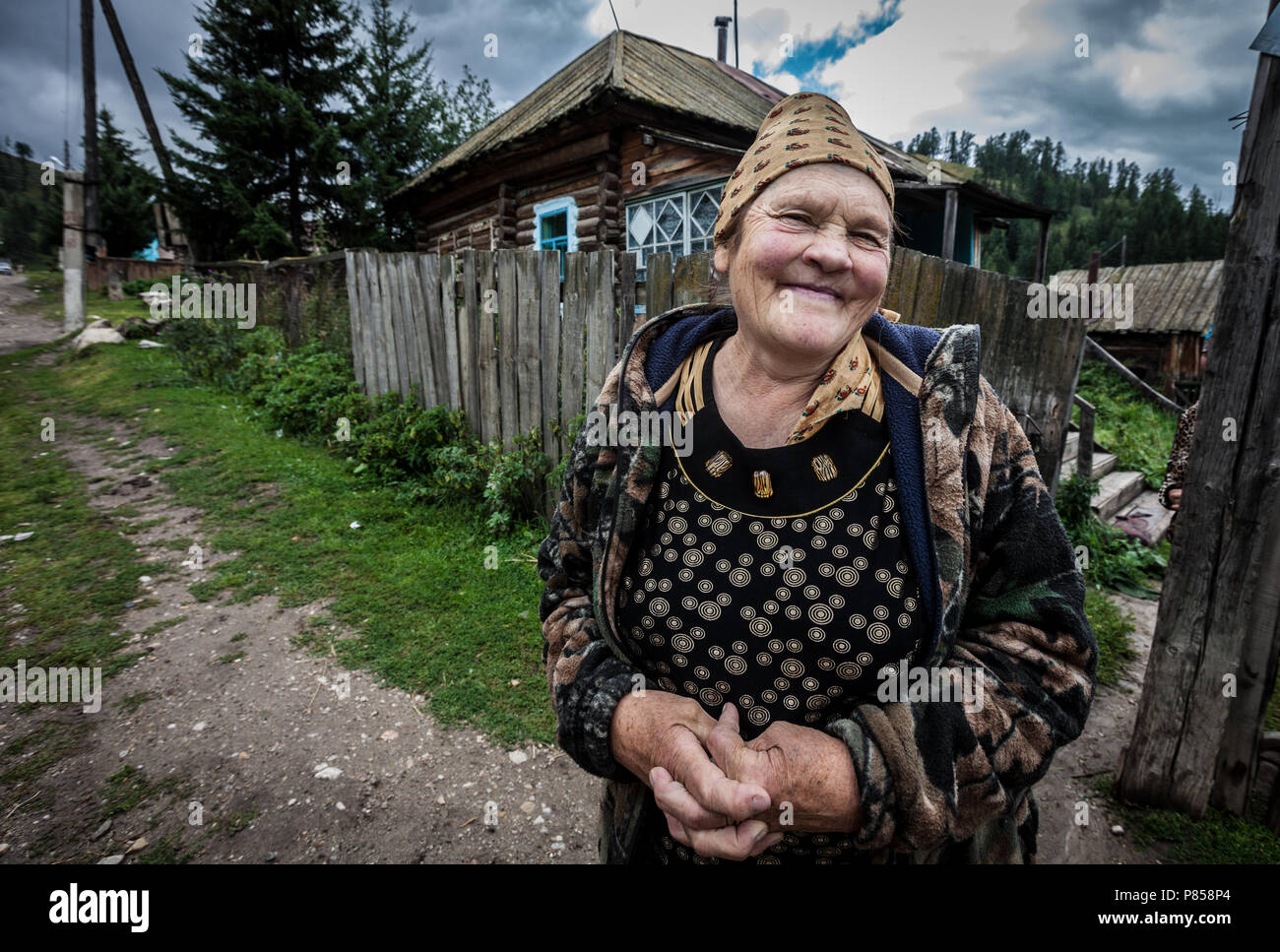Eine alte lächelnde Frau, in Kazakistan, vor ihrem Haus. Stockfoto