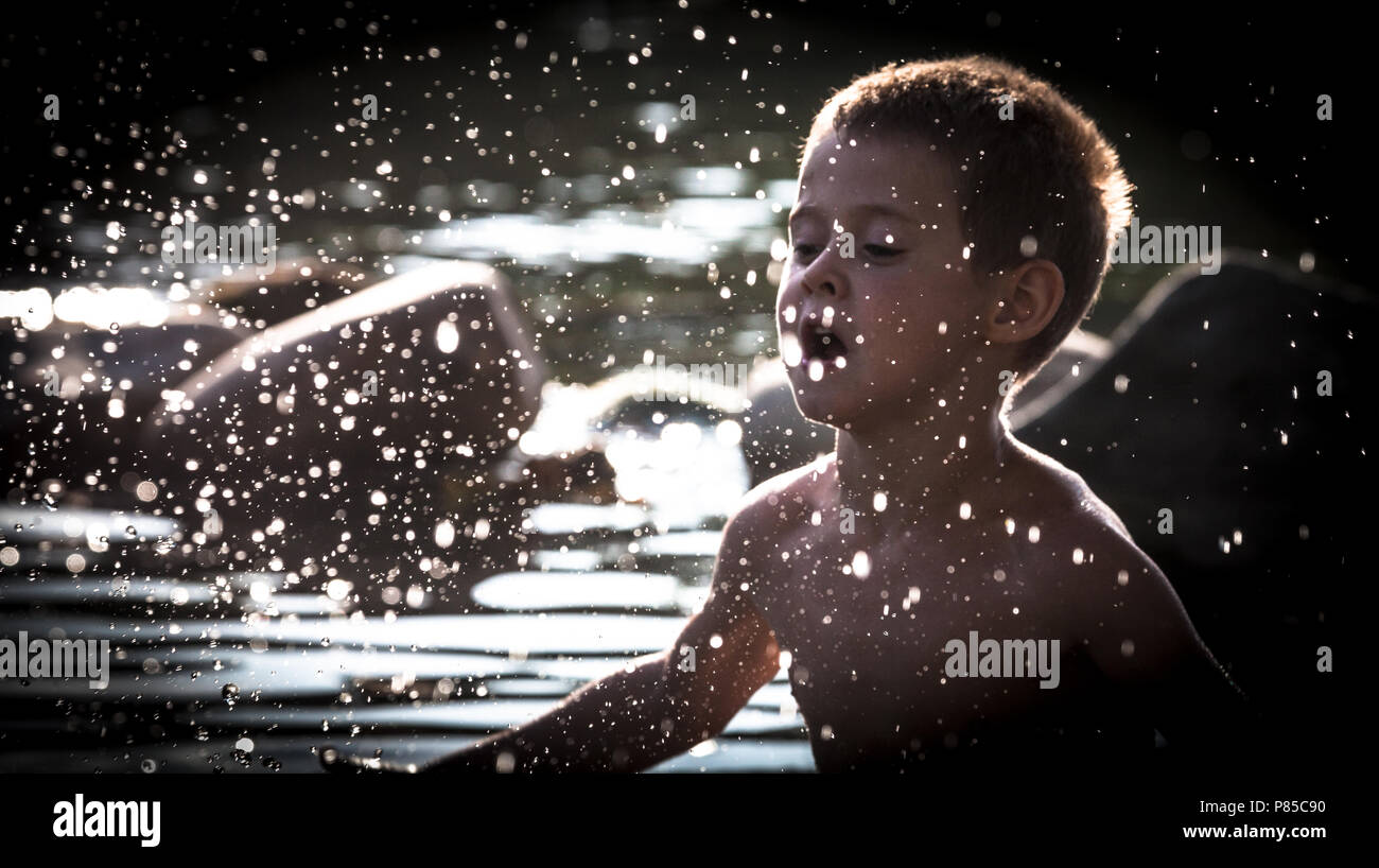 Ein Junge wird im Wasser spielen. Stockfoto
