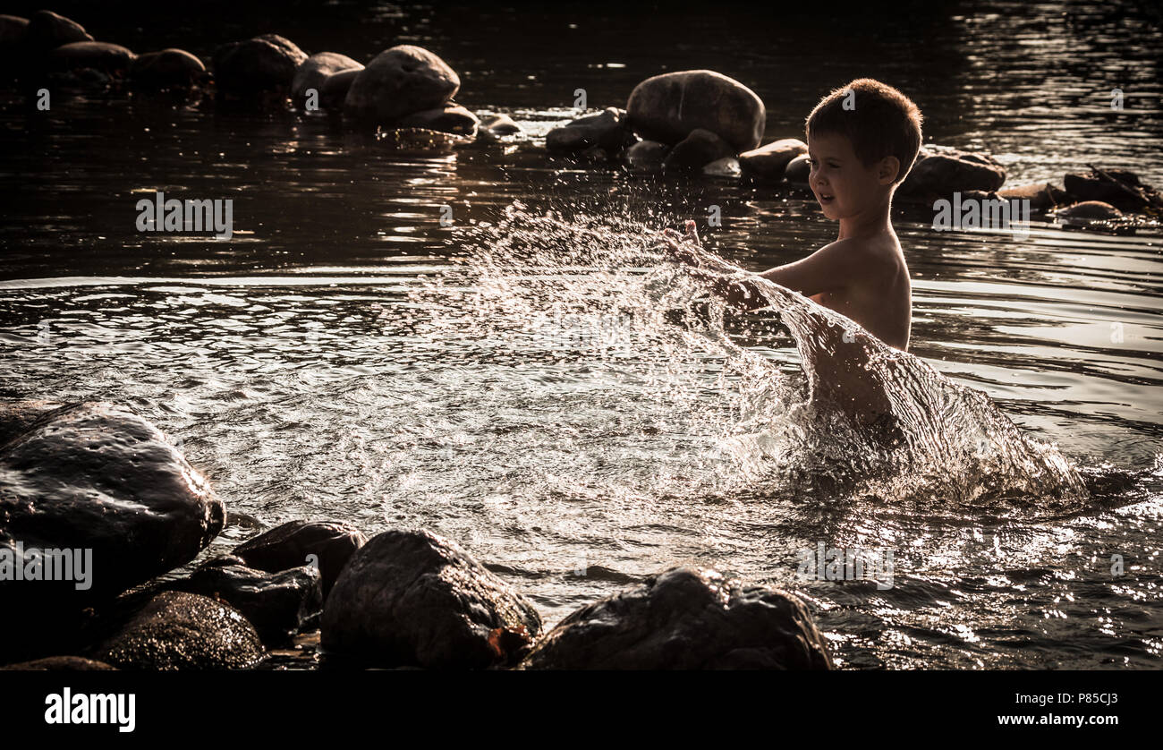 Ein Junge wird im Wasser spielen. Stockfoto