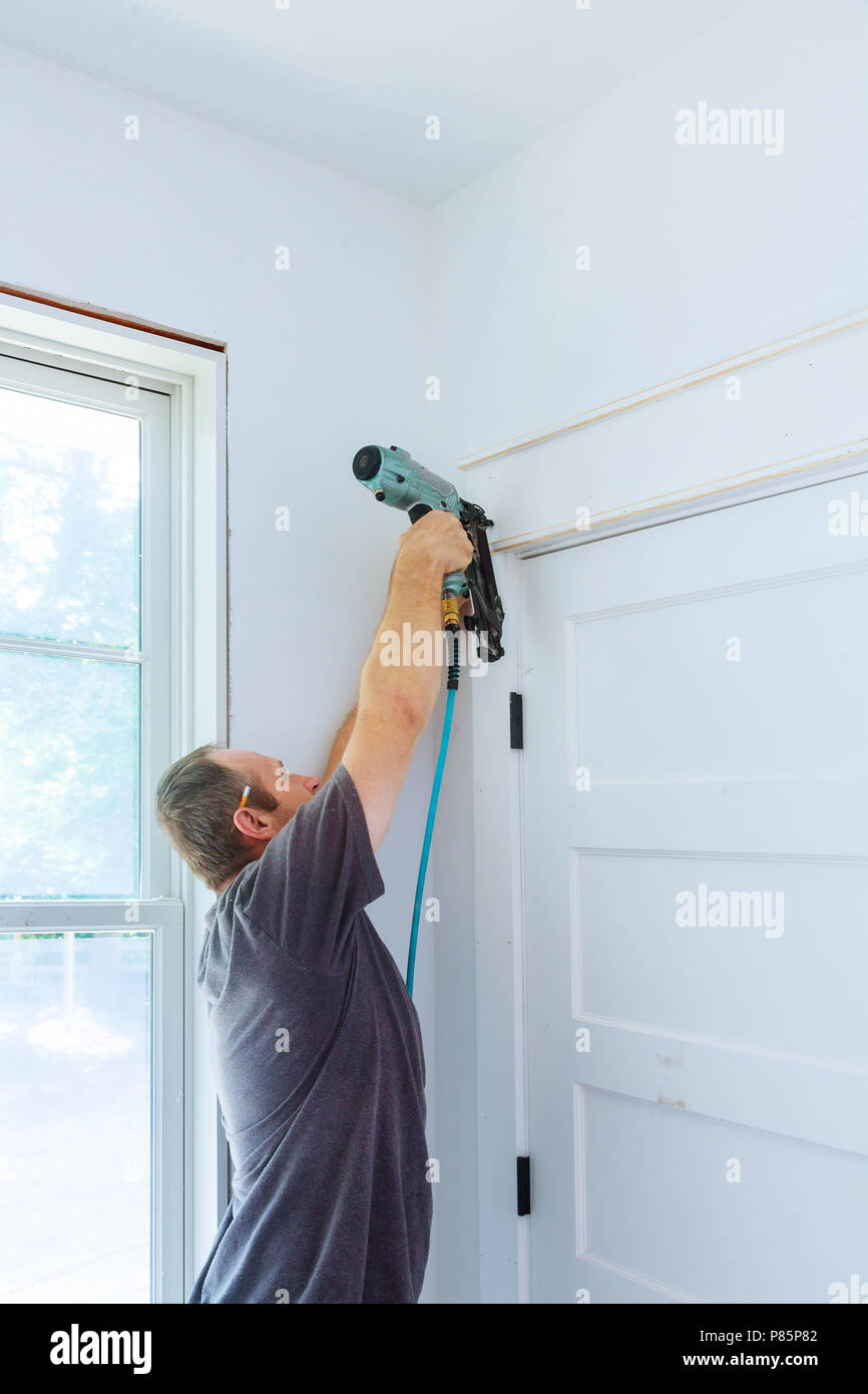 Tischler mit Bolzenschußgeräten zu leisten an der Tür, Verkleidung, mit der Warnung, dass alle Power Tools auf ihnen haben gezeigt, Sicherheitskonzept Stockfoto