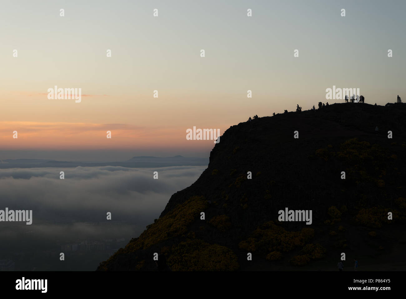 Touristen am Sitz des Arthur beobachten Meer Nebel (5,2Km) engulfing Edinburgh, die Hauptstadt Schottlands, kurz vor Sonnenuntergang. Stockfoto