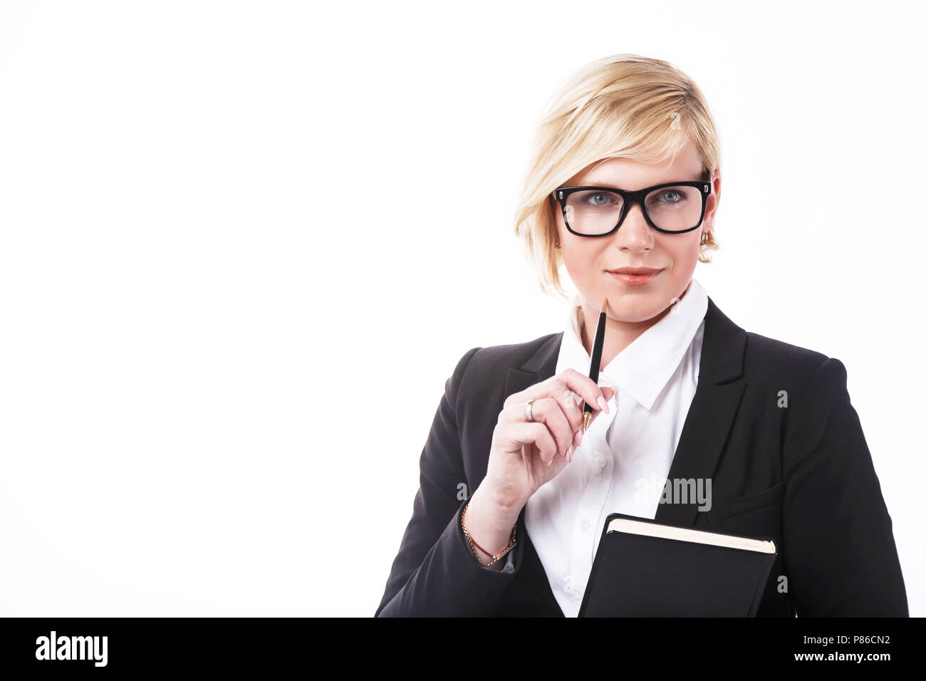 Nach businesslady in schwarzer Jacke und Brille holding Notizbuch und Stift gekleidet vor dem weißen Hintergrund mit Copyspace Stockfoto