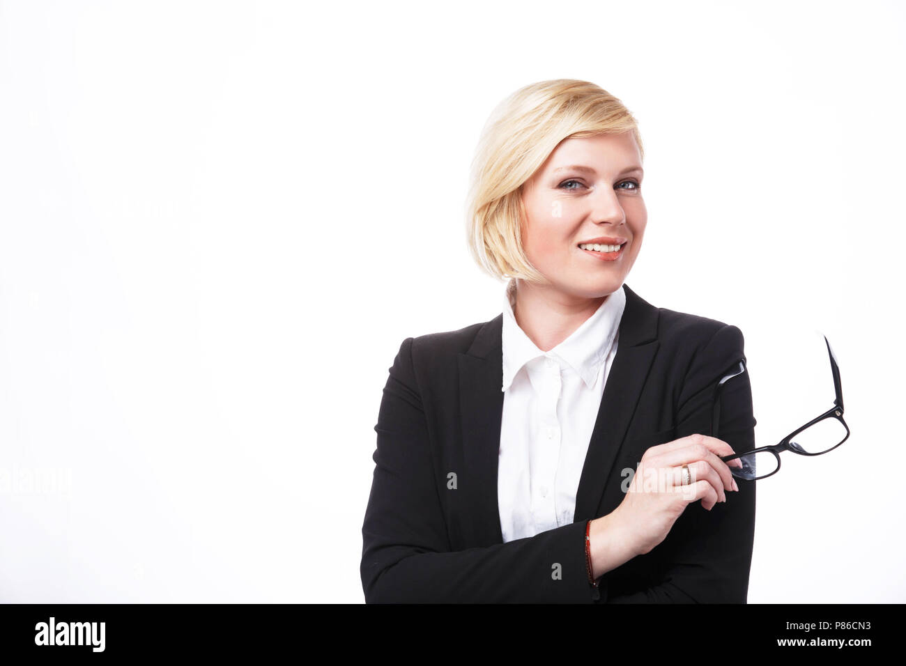Geschäftsfrau, gekleidet in schwarzen Jacke und Brille lächelnd vor dem weißen Hintergrund mit Copyspace Stockfoto