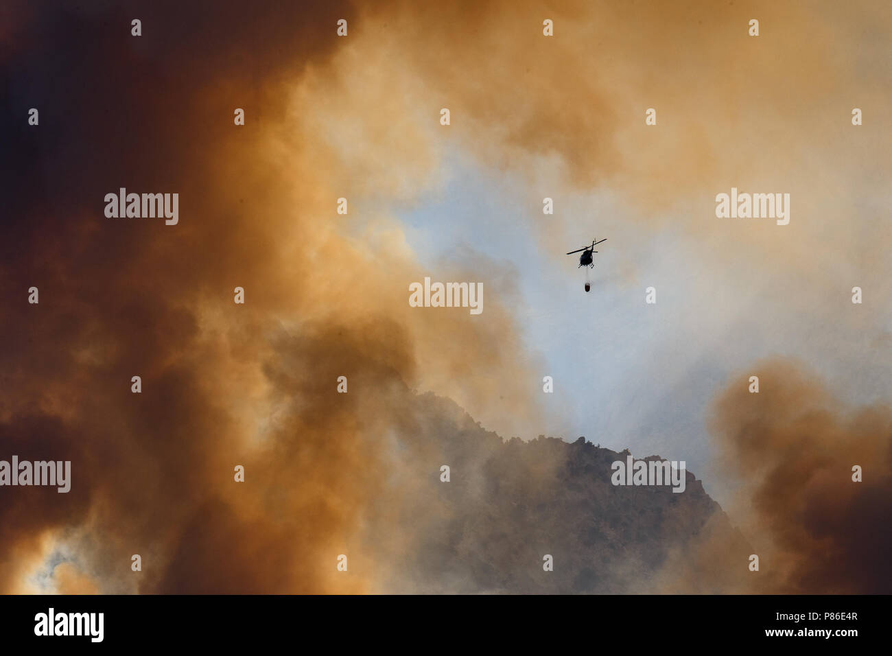 Alabama Hills, Lone Pine, CA. Juli 8, 2018. Ein Hubschrauber kämpft gegen die Georges Brand in den Alabama Hills westlich von Lone Pine, CA in der östlichen Sierra Nevadas. Die Ursache wird derzeit untersucht. Blitz hatte in der Gegend beobachtet. Feuerwehr von Inyo National Forest, das Büro des Land-Managements (BLM), CALFIRE und örtlichen Feuerwehren sind die löscharbeiten mit Hilfe von Air Tanker und Hubschrauber. Die Hubschrauber sind Zeichnung Wasser aus dem in der Umgebung California Aquädukt. Stockfoto