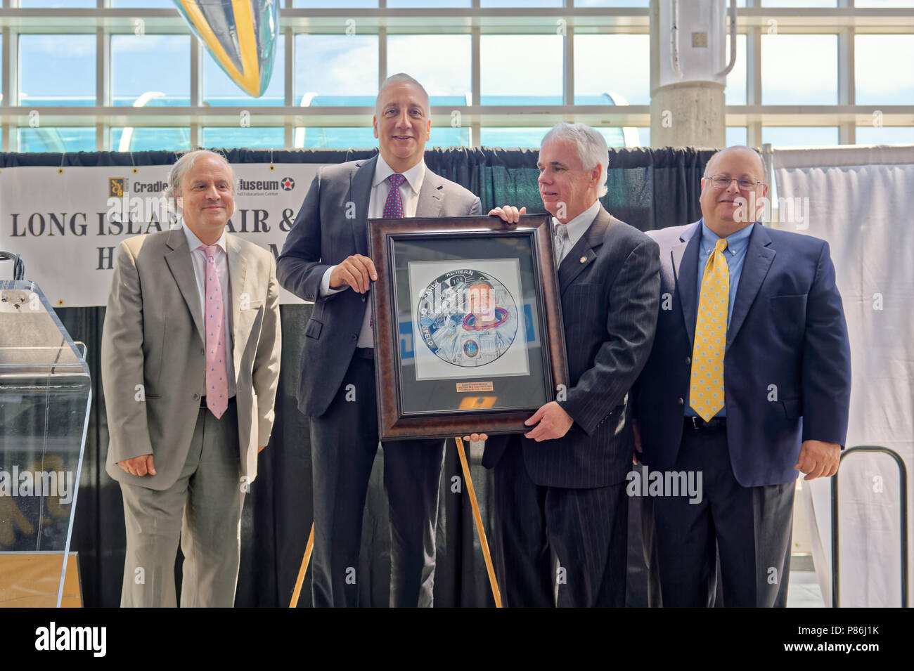 Garden City, New York, USA. 21 Juni, 2018. Auf der Bühne, L-R, JOSHUA STOFF, Kurator der Wiege der Luftfahrt Museum, der ehemalige NASA-Astronaut MICHAEL MASSIMINO; ANDREW PARTON der Executive Director der CAM; und Greg SANTI das Human Resources Manager bei Curtiss Wright, mit offiziellen Abbildung: Long Island Air & Space Hall des Ruhmeingezogenen Massimino am 10. jährliche Mittagessen an der Wiege der Luftfahrt darstellen. Quelle: Ann Parry/ZUMA Draht/Alamy leben Nachrichten Stockfoto