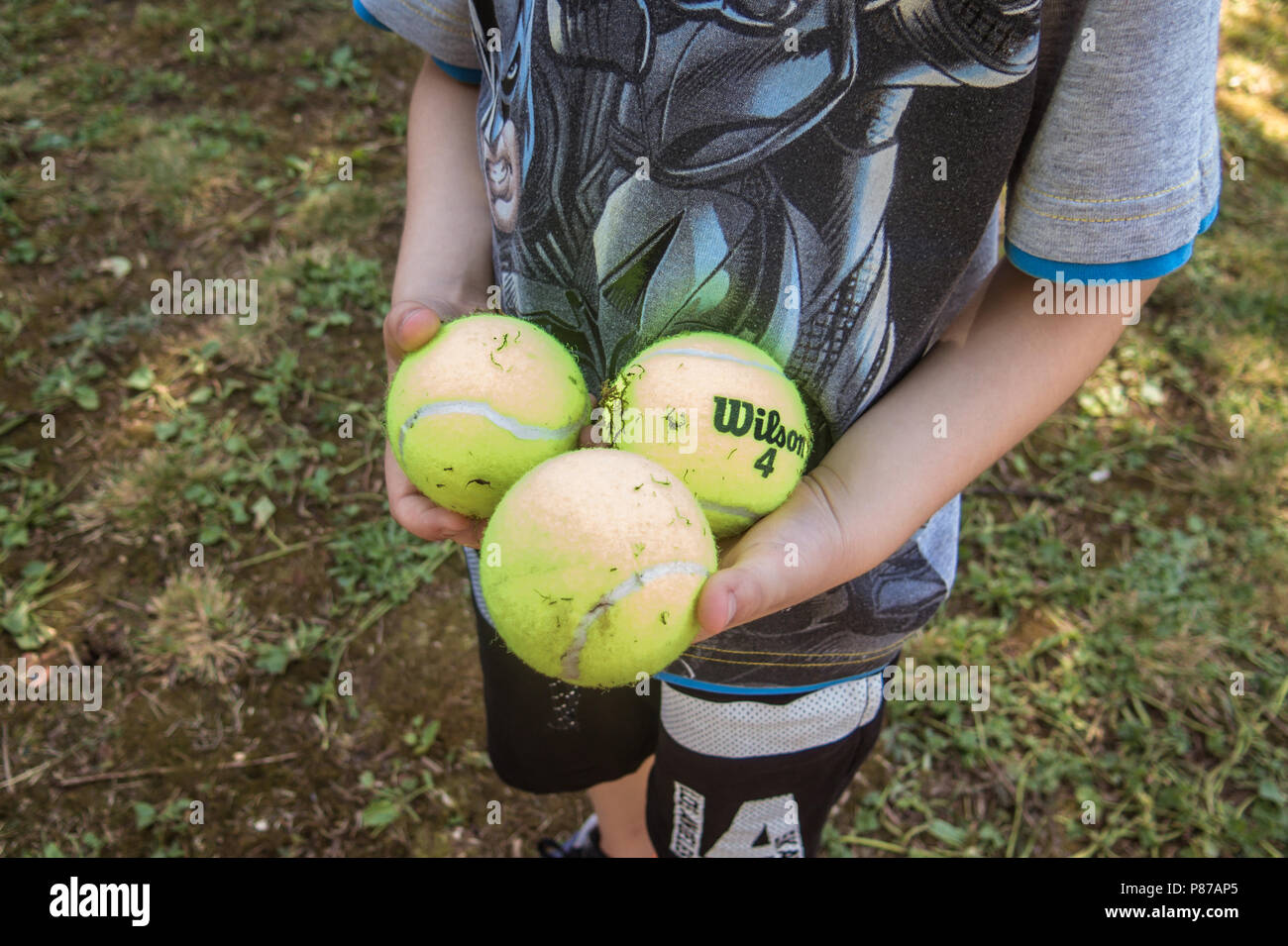 Nahaufnahme der Jungen Hände halten drei Tennisbälle Stockfoto