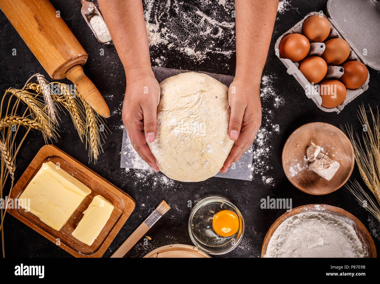 Teig Hintergrund. Frischen Teig mit verschiedenen Zutaten auf schwarzem Hintergrund Stockfoto