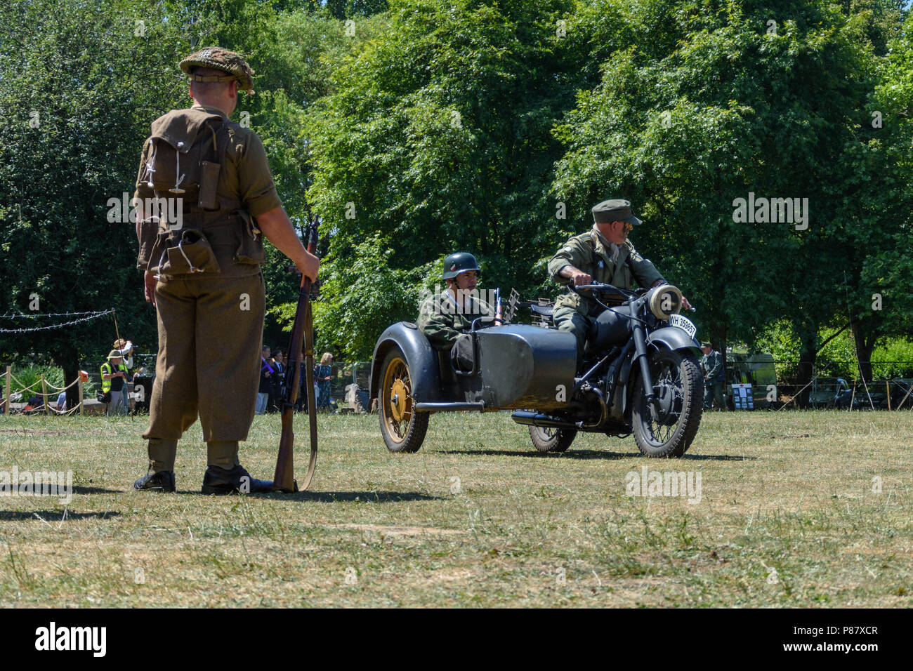 Ein Schauspieler wie 2. Weltkrieg alliierte Soldat Uhren Akteure spielen deutsche Soldaten in Motorrad seitenwagen an Streitkräfte feier Wochenende in Bradford-on-Avon Stockfoto