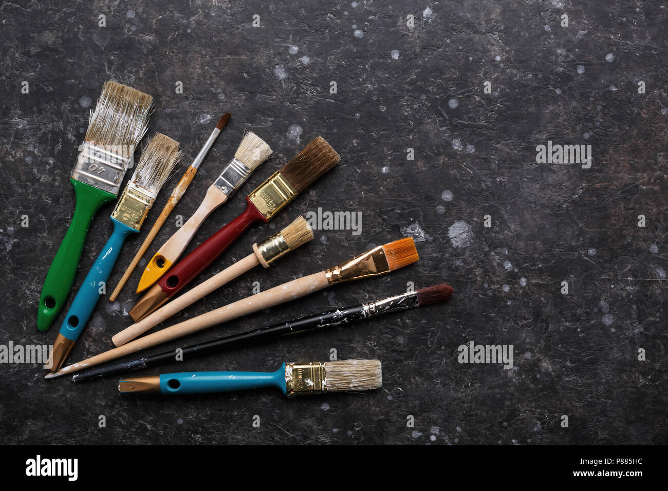 Alten grunge Pinsel auf strukturierte dunkelgrauer Hintergrund mit kopieren. Ansicht von oben, Werkzeuge. Stockfoto