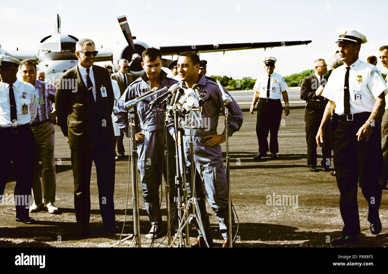 Astronauten John W. Young (links), Pilot; I. und Virgil Grissom, Befehl Pilot, stehen an Mikrofone bei Skid Streifen des Kap nach von der Recovery Schiff geflogen, USS Intrepid Stockfoto