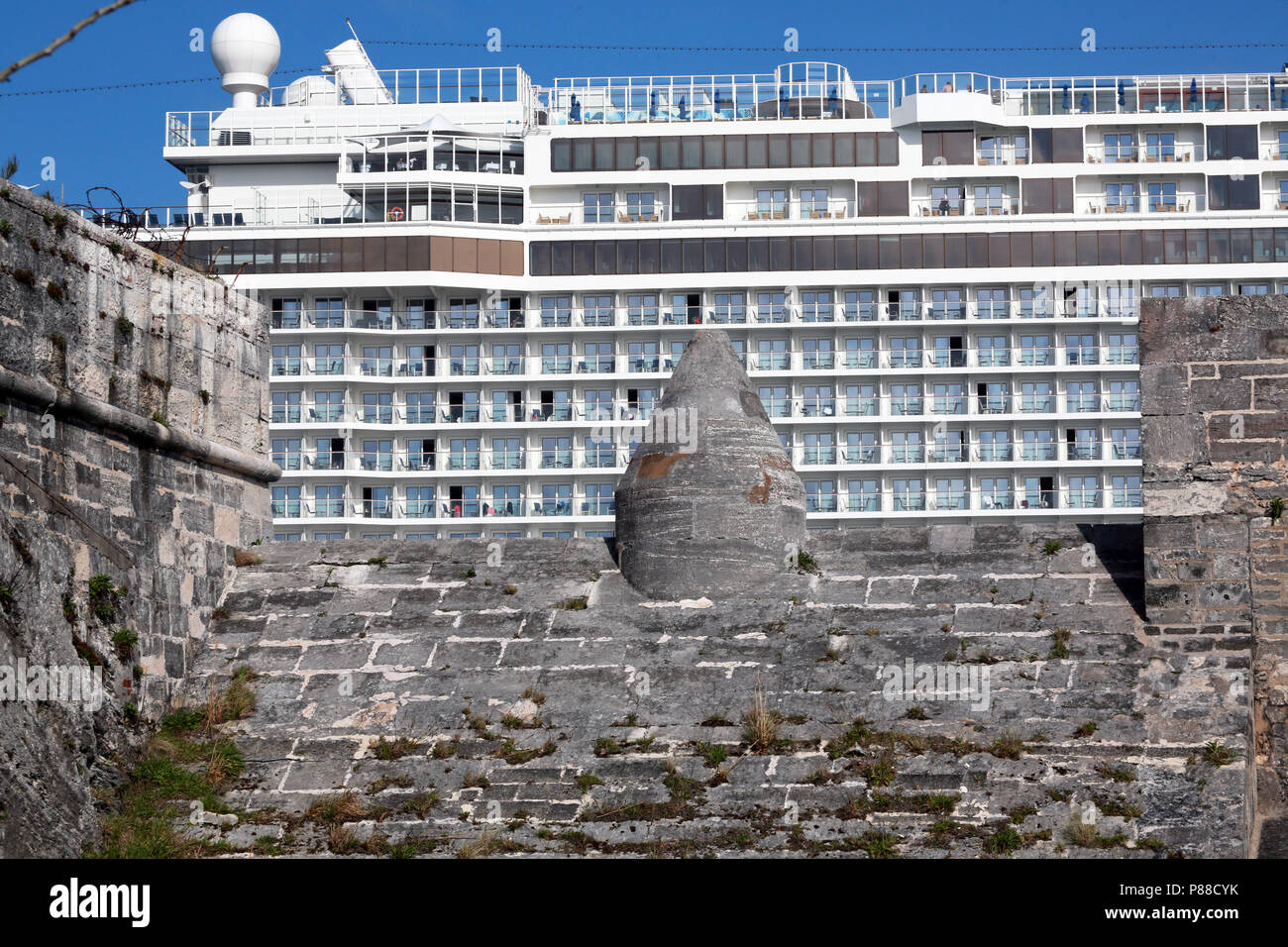 Kontrast der modernen Kreuzfahrtschiff hinter historischen Stein abwehrmauer der Naval drydock Stockfoto