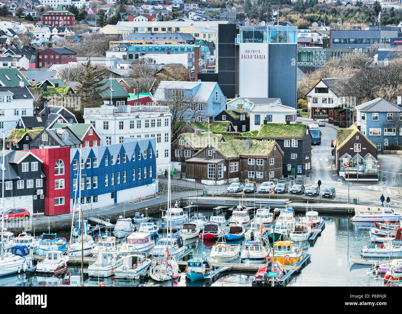 26. April 2018: Tórshavn, Färöer Inseln - Der Hafen, traditionelle Gras roofed Häuser und das Hotel Hafnia im Zentrum der Stadt. Stockfoto