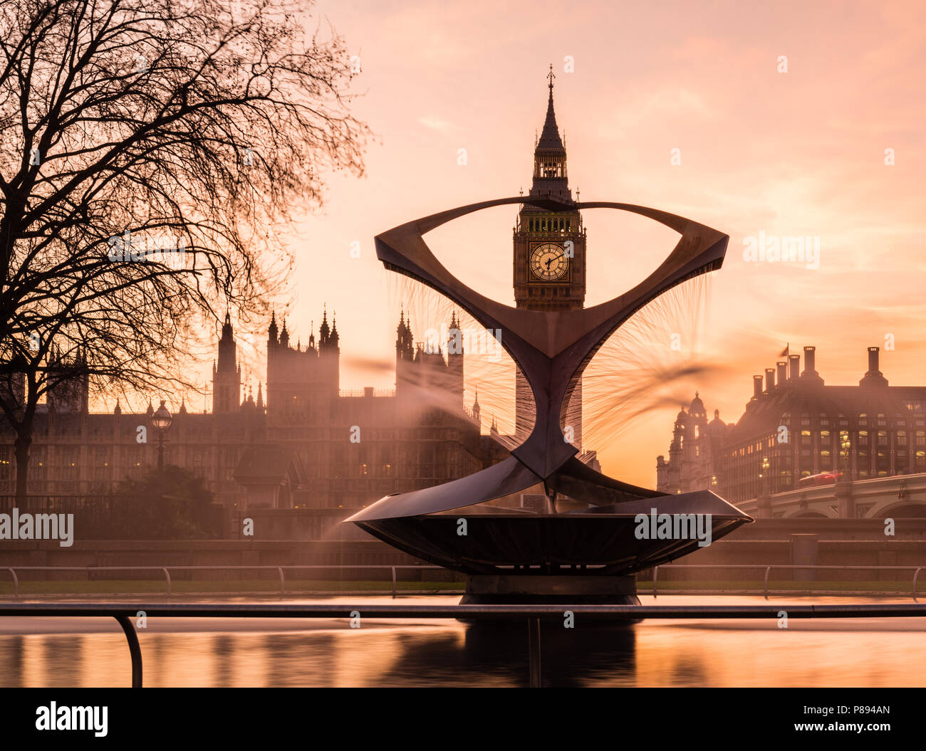 Orange Sonnenuntergang über den Big Ben und die Houses of Parliament in London, einschließlich die Westminster Bridge und eine Statue und Brunnen im St. Thomas hospital Gärten Stockfoto