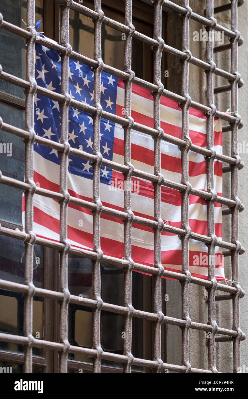 Amerikanische Flagge hinter Fenster Sicherheit Bars, alte Stadt Straße in Lucca, Toskana, Italien, Europa, Stockfoto