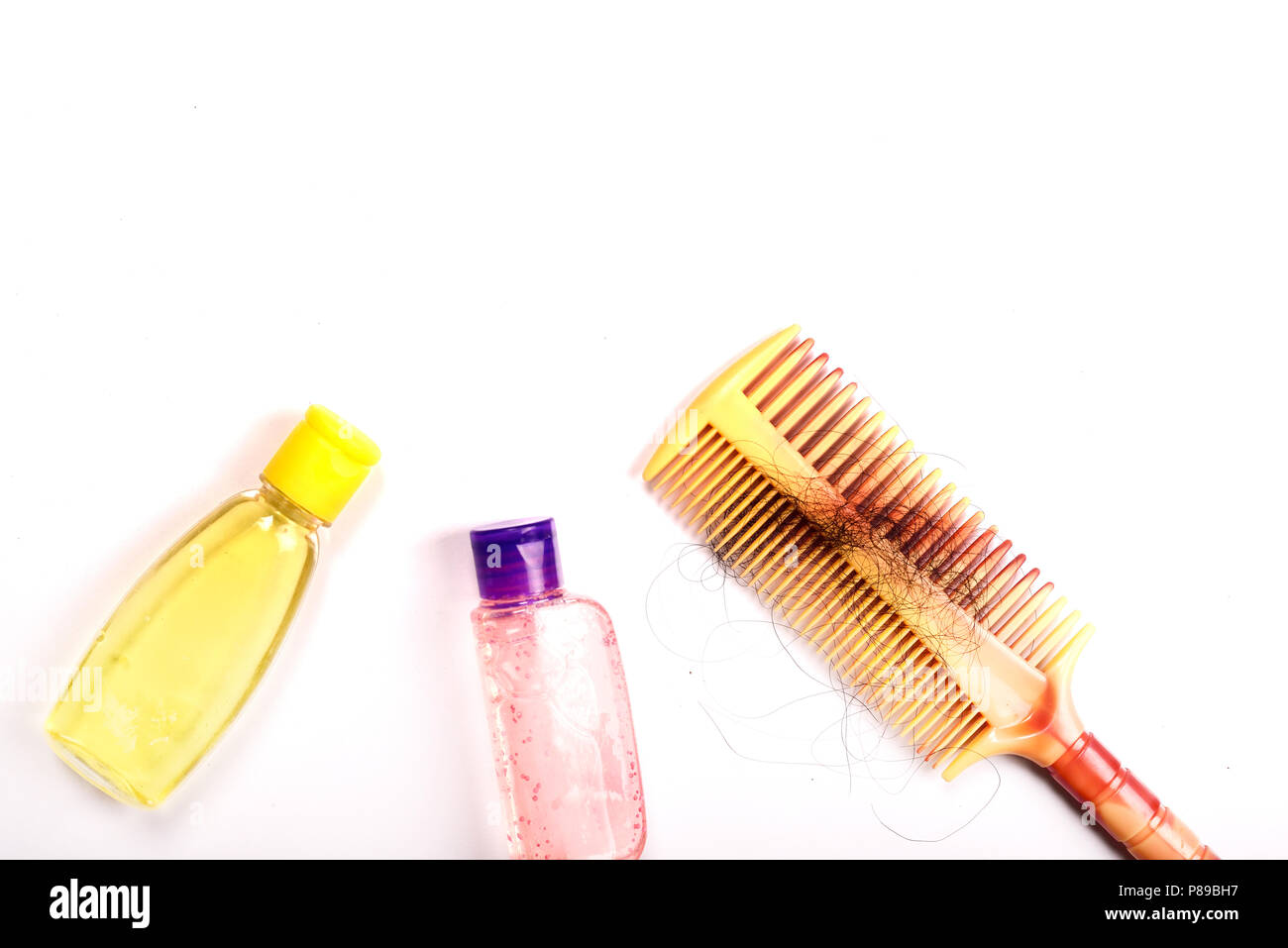 Kamm mit Haar und Shampoo auf weißem Hintergrund Stockfoto